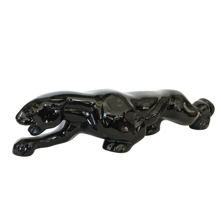 Mid-Century panther art pottery ceramic statue featuring a high glazed black finish and detailed form of a panther ready to strike. This piece is 18 inches long. 