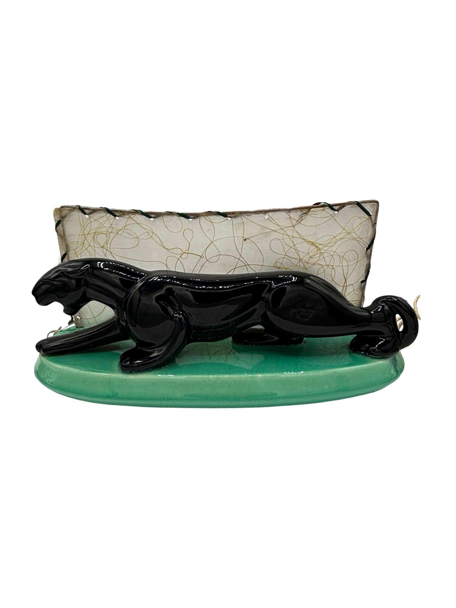 Lampe statue panthère en céramique d'art du milieu du siècle, avec une finition noire hautement émaillée et la forme détaillée d'une panthère prête à frapper, avec un abat-jour rétroéclairé en fibre de verre à points Whipple. Cette pièce mesure 13