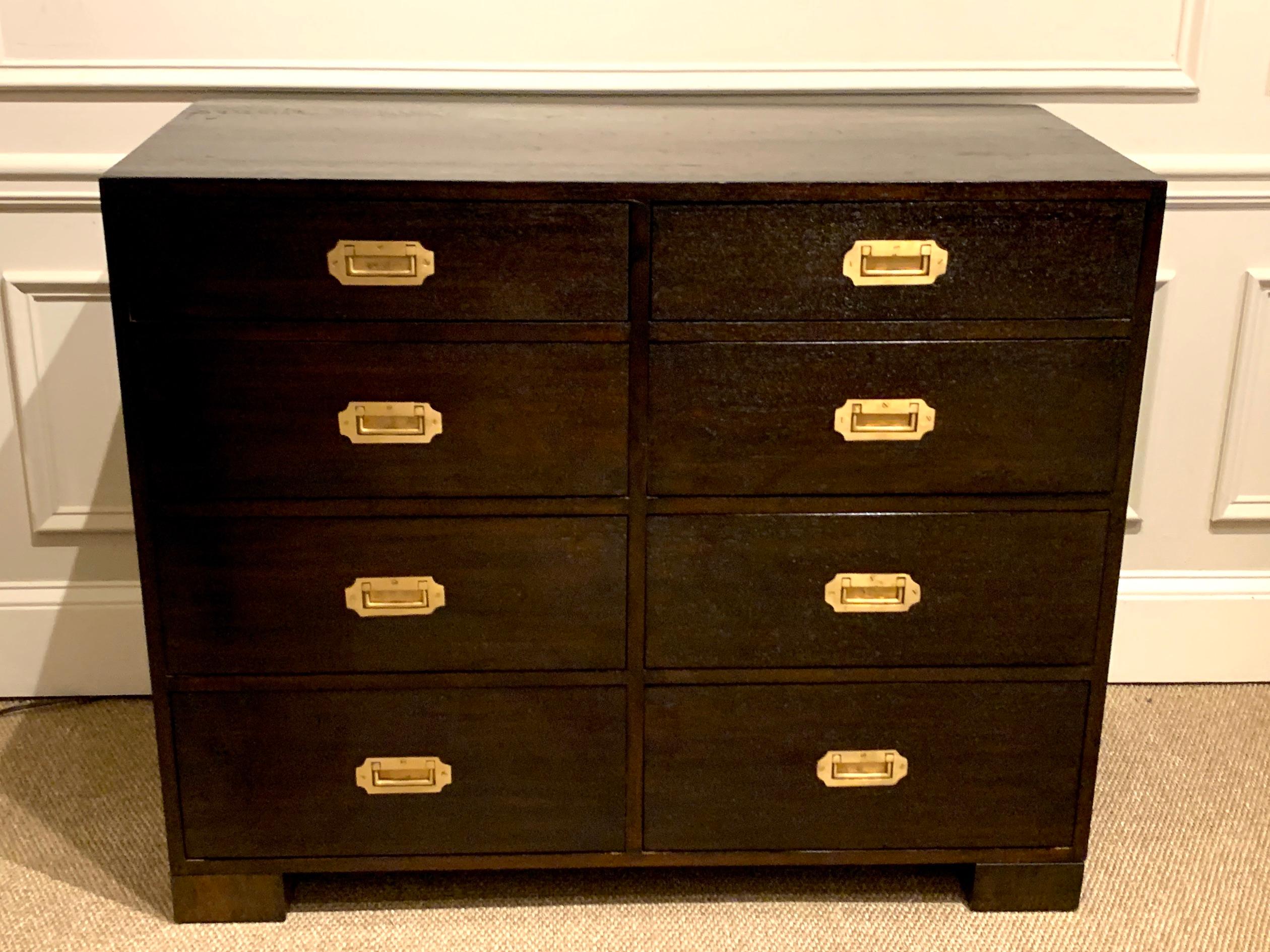 Midcentury black-stained hardwood and brass Campaign style chest, of rectangular form fitted with eight slightly graduated drawers with brass inset handles, raised on four block feet. Nice wood grain, hard to photograph, one piece construction, a