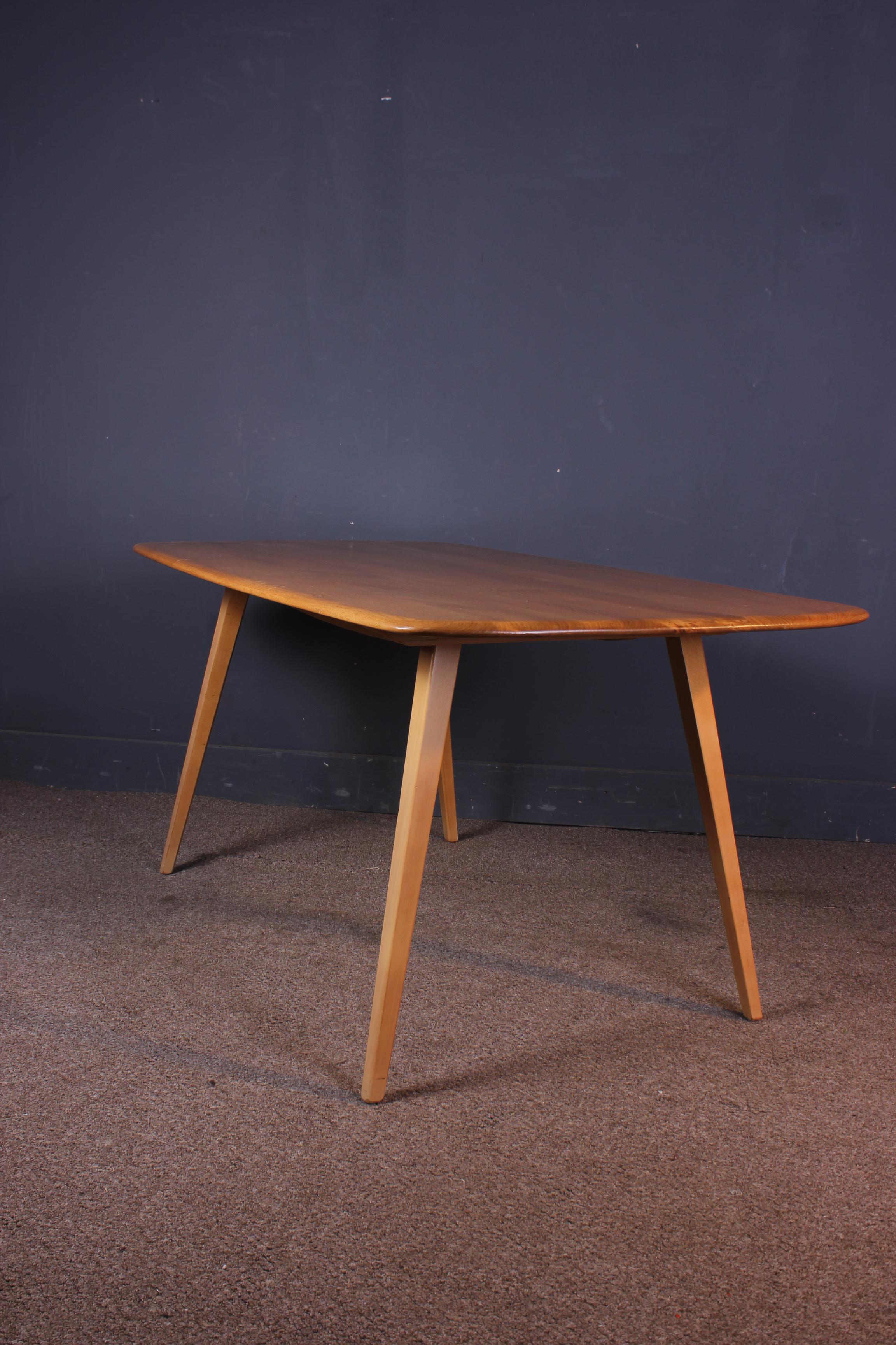 A beautiful vintage/midcentury Ercol blonde plank dining table. It is made from elm and beech and is a very practical size and is designed for six people. It has a smoothly sculptured solid wood top with gracefully shaped beech legs. It is in good