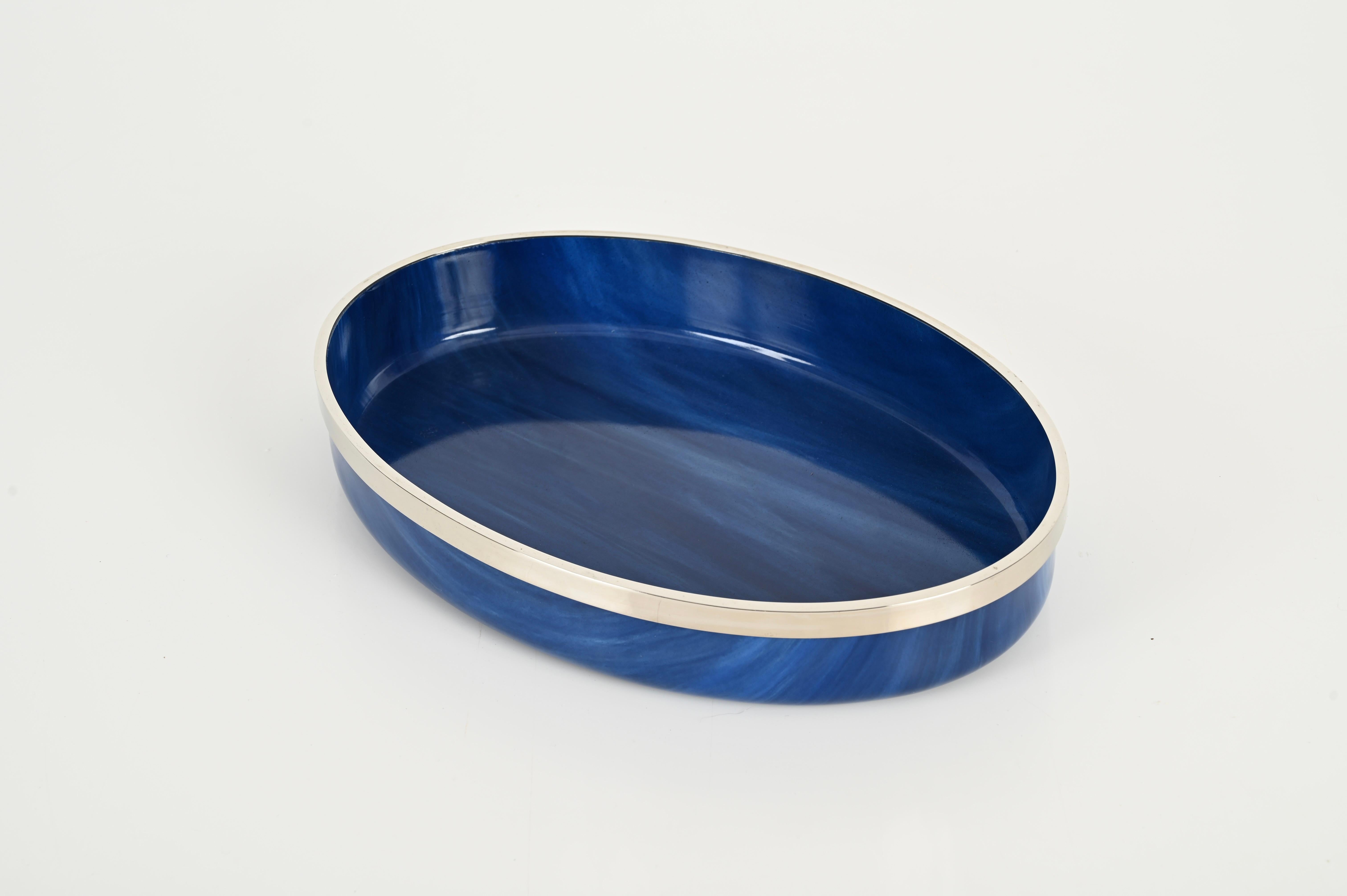 Excepcional bandeja de servir de mediados de siglo en un impresionante lucite azul efecto océano con borde cromado. Este centro de mesa único se fabricó en Italia en los años 80.

La lucita azul con ligeros matices de blanco es sencillamente