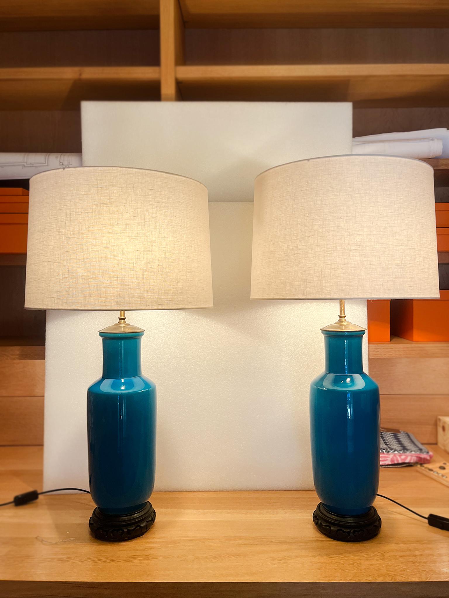 Queste eleganti lampade da tavolo del Midcentury combinano colori vivaci e forme minimaliste. Sono stati disegnati da Warren Kessler e sono costituiti da corpi in porcellana con uno splendido smalto blu e basi in legno intagliato. Le lampade sono