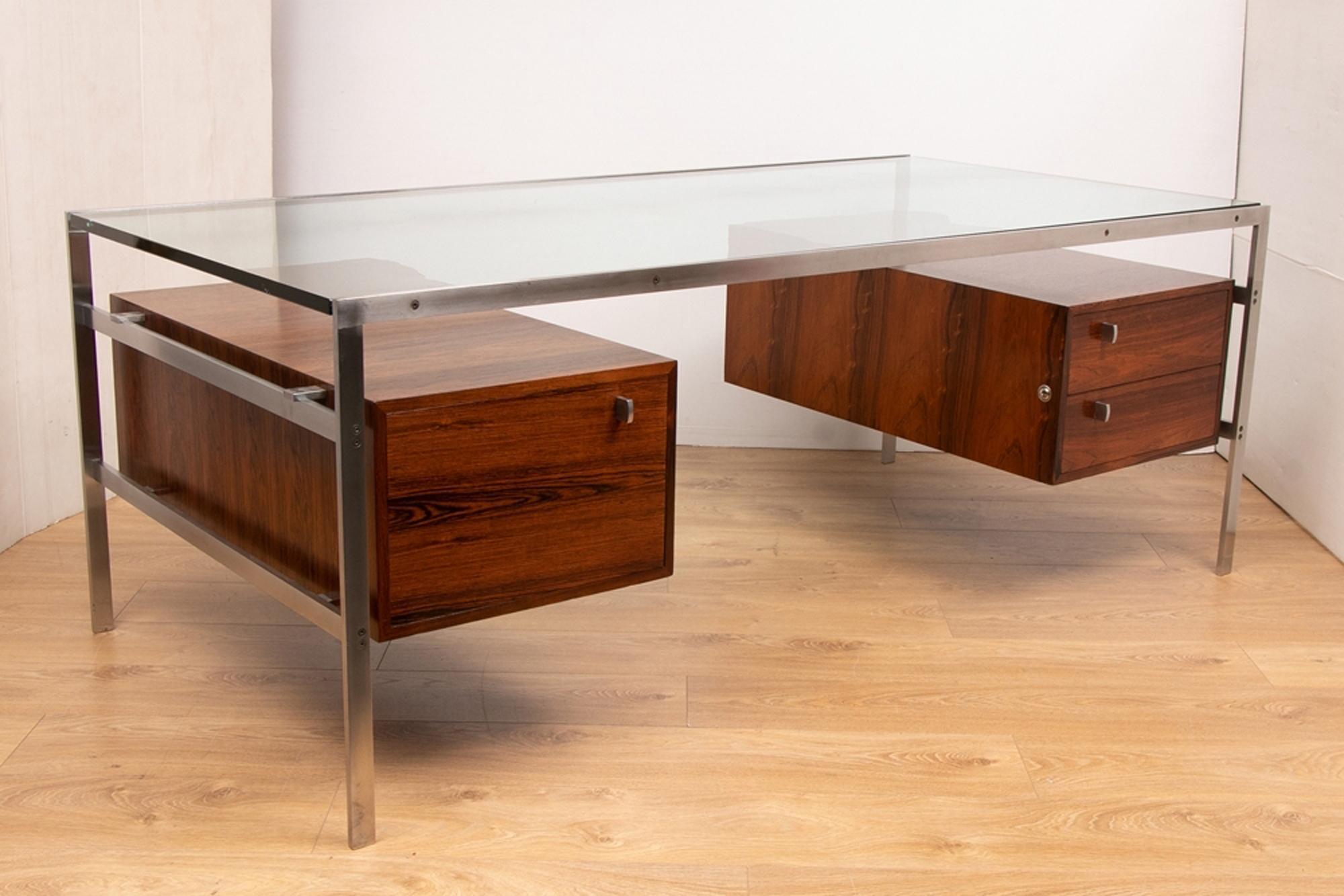 A midcentury model BO 555 glass, rosewood and metal desk designed by Preben Fabricius and Jorgen Kastholm. The desk features a brushed metal frame, glass top and three rosewood drawers.