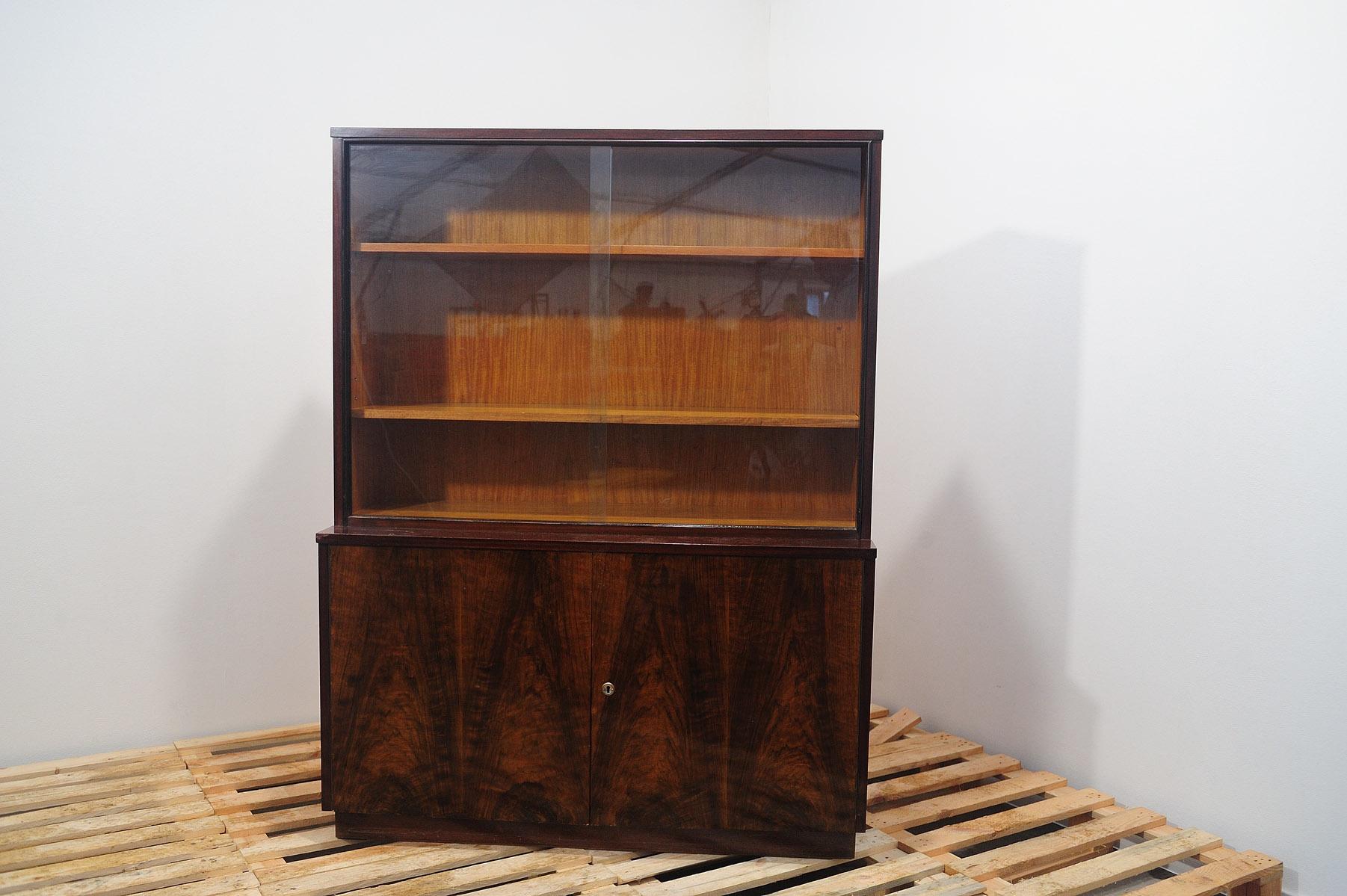 This bookcase was made by Setona company in the former Czechoslovakia in the 1950´s.

It features a regular shapes, a solid structure and a geometric base on which the library stands. It´s made of walnut wood.
In good Vintage condition, showing