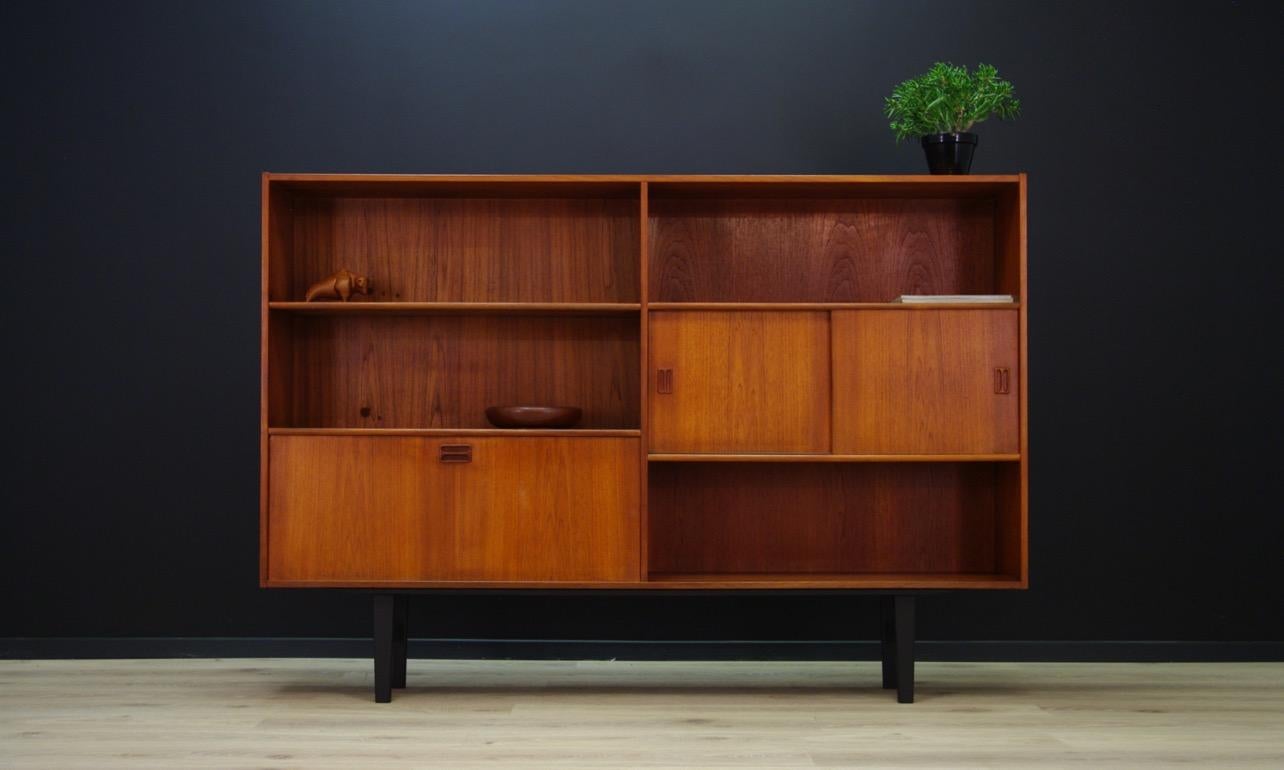 Bookcase from 1960s-1970s, minimalistic Scandinavian design. Produced in Westergaard Møbelfabrik. A spacious bar in the bottom section and shelves behind a sliding doors. Surface veneered with teak. Preserved in good condition (minor scratches,