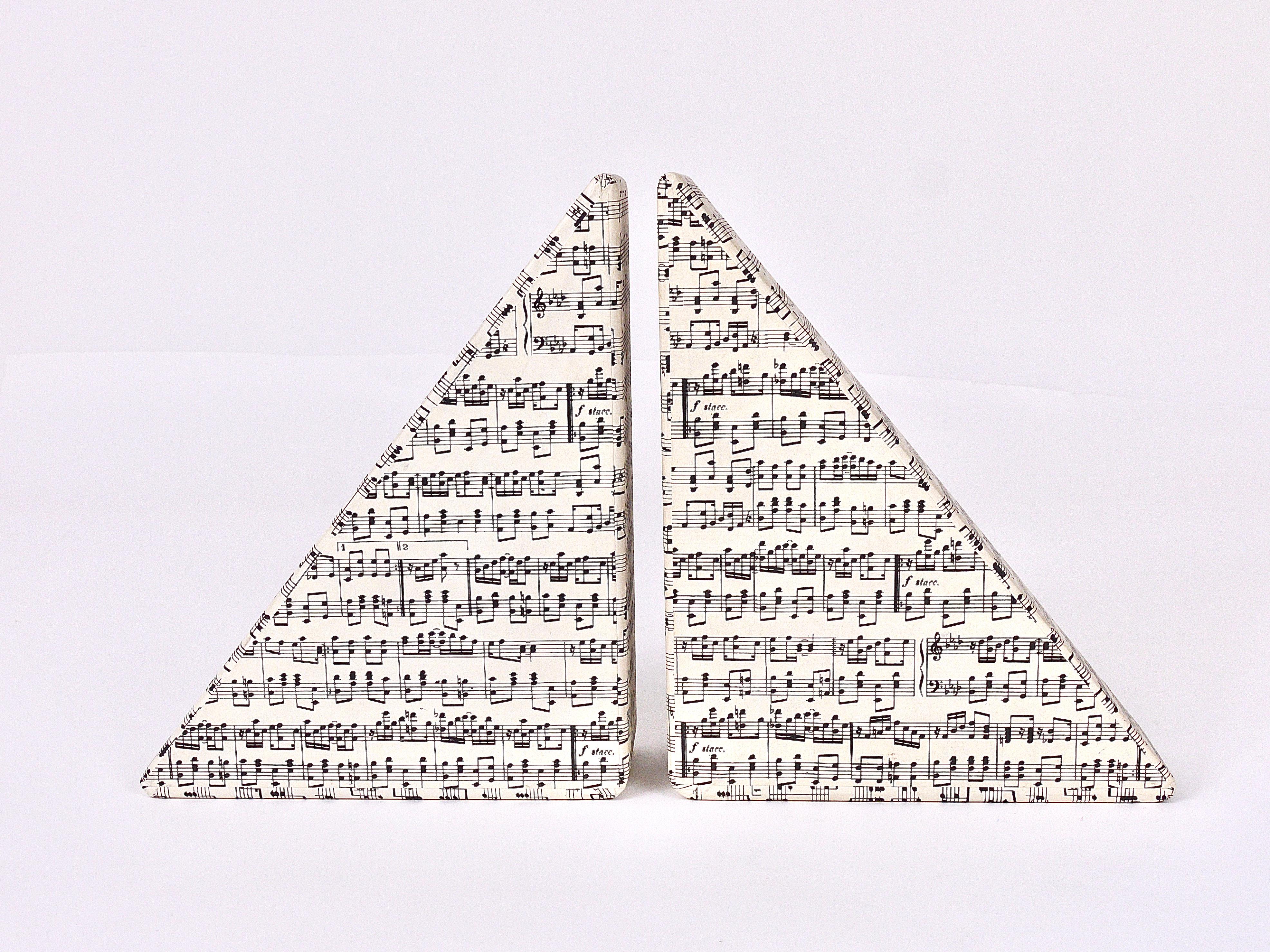 A pair of lovely and large triangular Midcentury book ends from the 1950s, executed by Tassotti & Figli, Bassano, Italy. Made of wood, covered with premium quality decor paper with a decorative music sheet pattern. Labeled on its underneath. In very