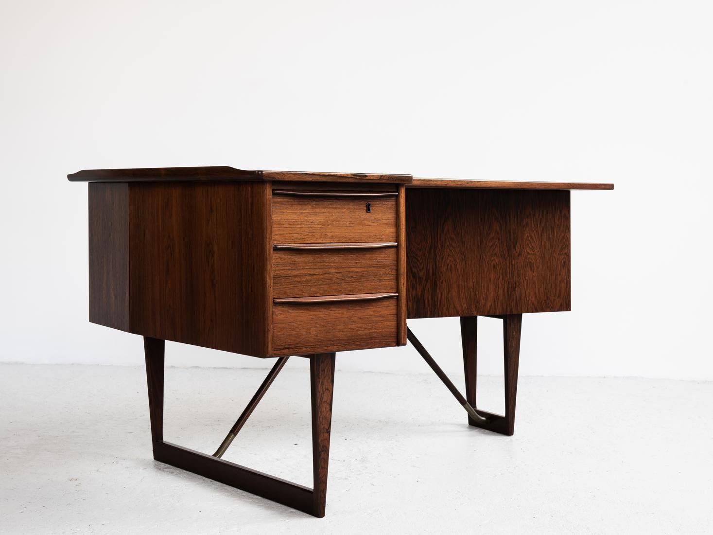 Midcentury boomerang desk designed by Peter Løvig Nielsen and manufactured by Hedensted in Denmark in the 1960s. This beautiful design piece is made of high quality materials and manufacturing. It has 3 drawers in the front and a book shelf and bar