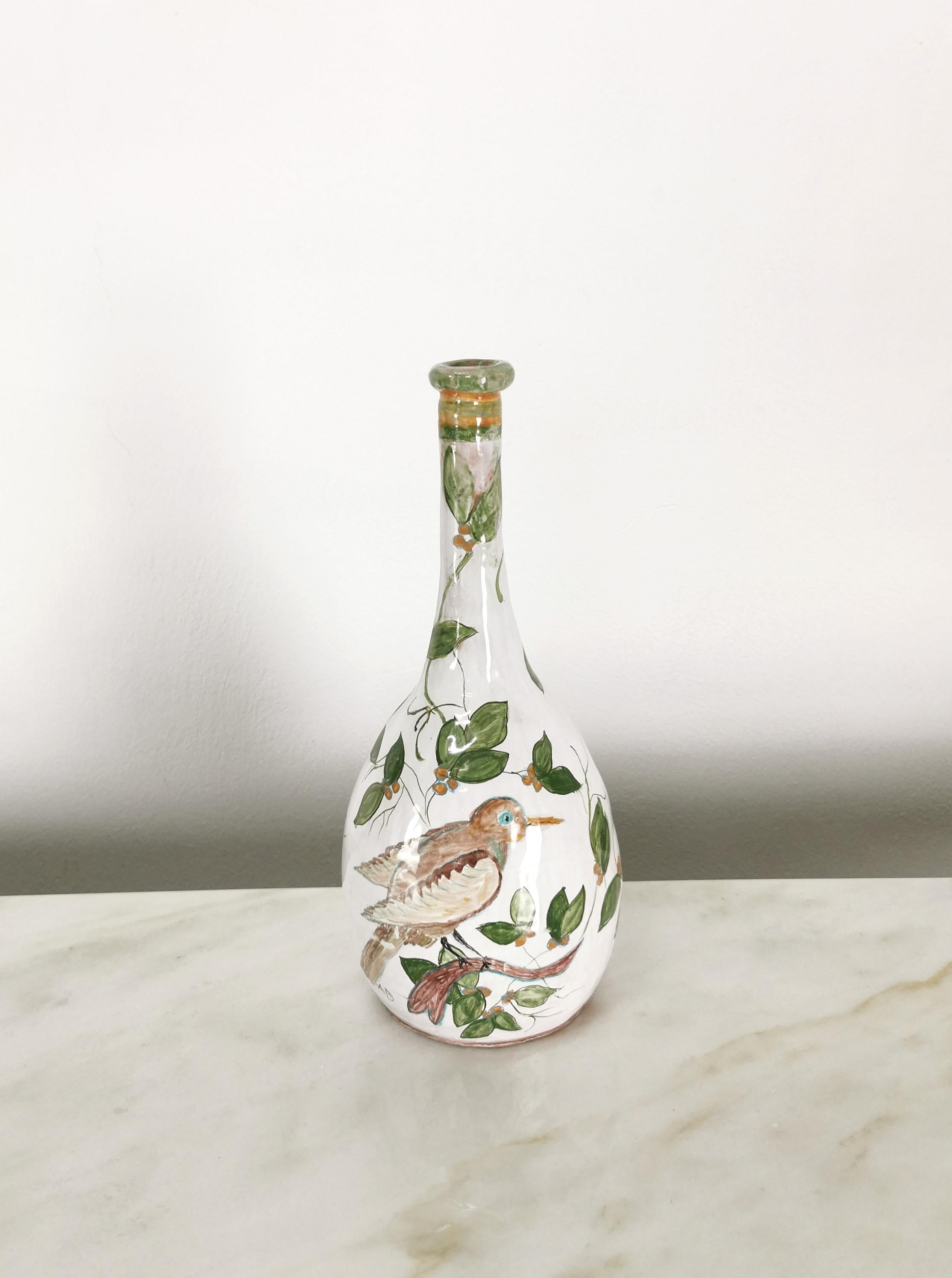 Bottle/decorative object signed AD, made in Italy in the 1970s. The bottle was made of white glazed ceramic/terracotta with a narrow neck and a belly painted with leaves and a bird resting on a twig.  Please watch the video and photos carefully,