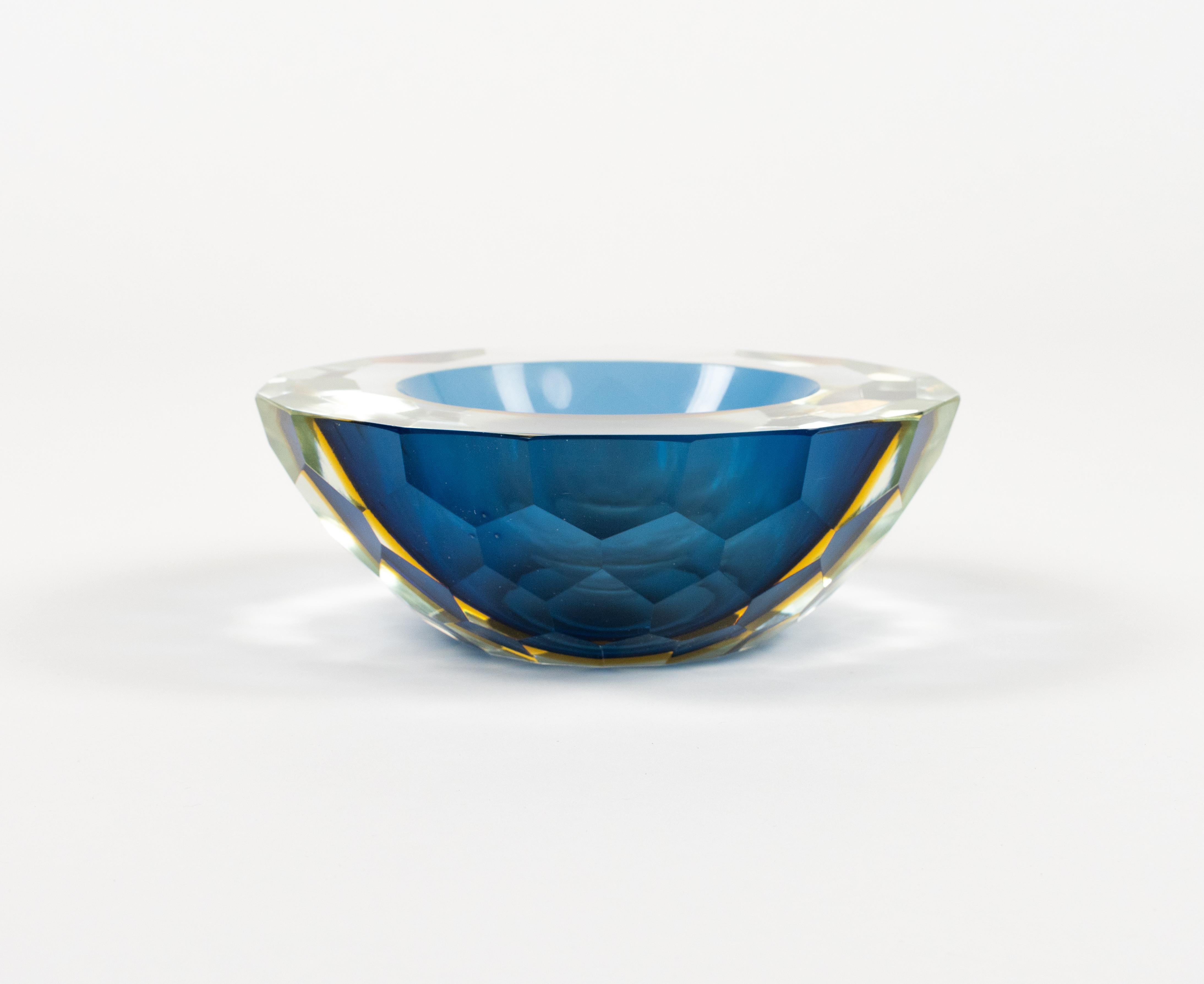 A beautiful midcentury Murano faceted art glass bowl or ashtray by Alessandro Mandruzzato.

Made in Italy in the 1970s.

The combination of blue and yellow 'Sommerso' cut-glass looks simply stunning.

The flat cut polished top and the geode form