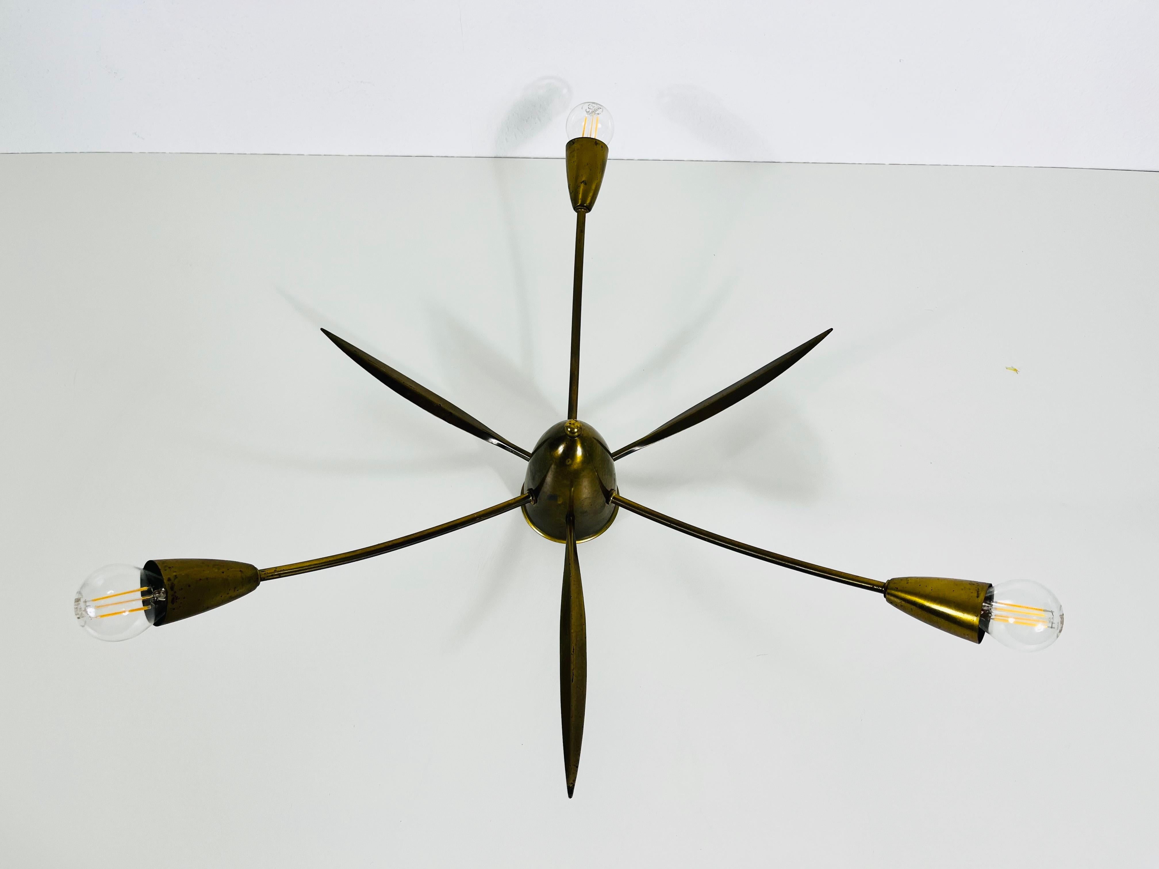 A Sputnik chandelier made in Germany in the 1950s. It is fascinating with its three brass arms, each of it with an E14 light bulb. The shape of the light is similar to a spider.

The light requires 3 E14 light bulbs. Very good vintage