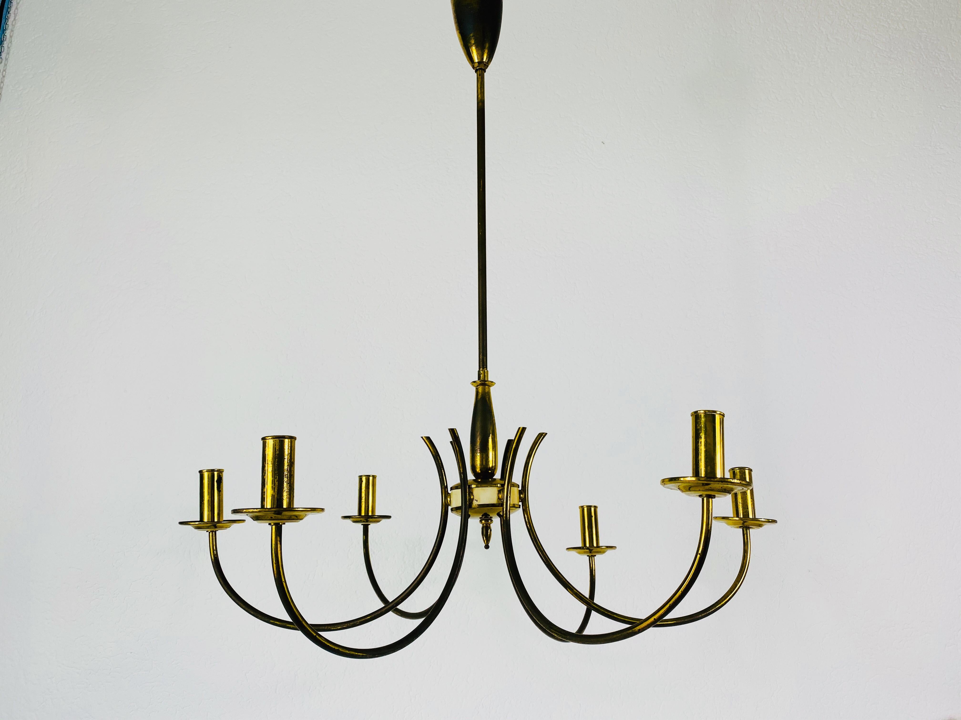 A midcentury chandelier made in Germany in the 1960s. It is fascinating with its rare arms and elegant design.

The light requires six E14 light bulbs.