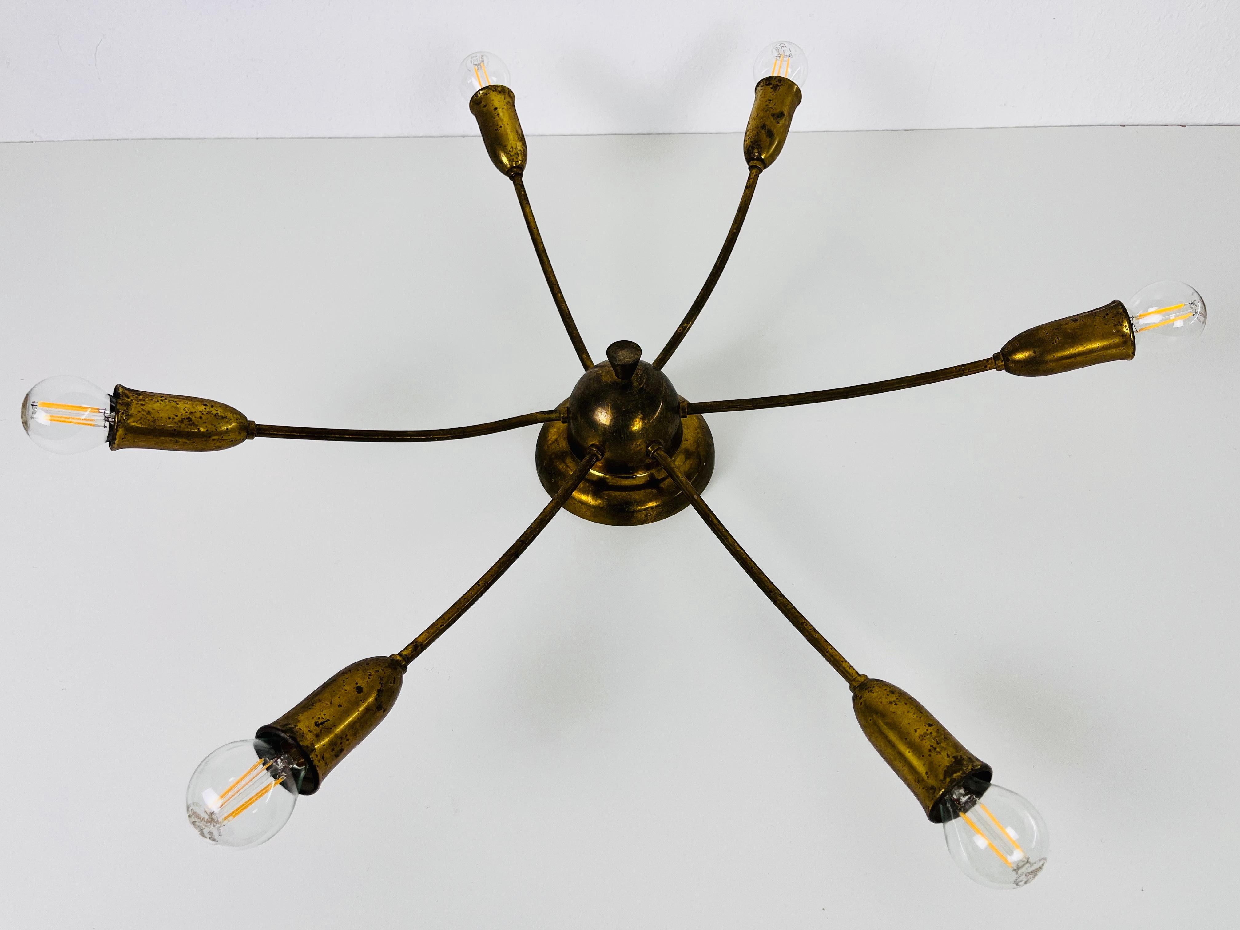 A brass Sputnik chandelier made in Germany in the 1960s. It is fascinating with its six brass arms, each of it with an E14 light bulb. The shape of the light is similar to a spider.

The light requires 6 E14 light bulbs. Works with both 120/220 V.
