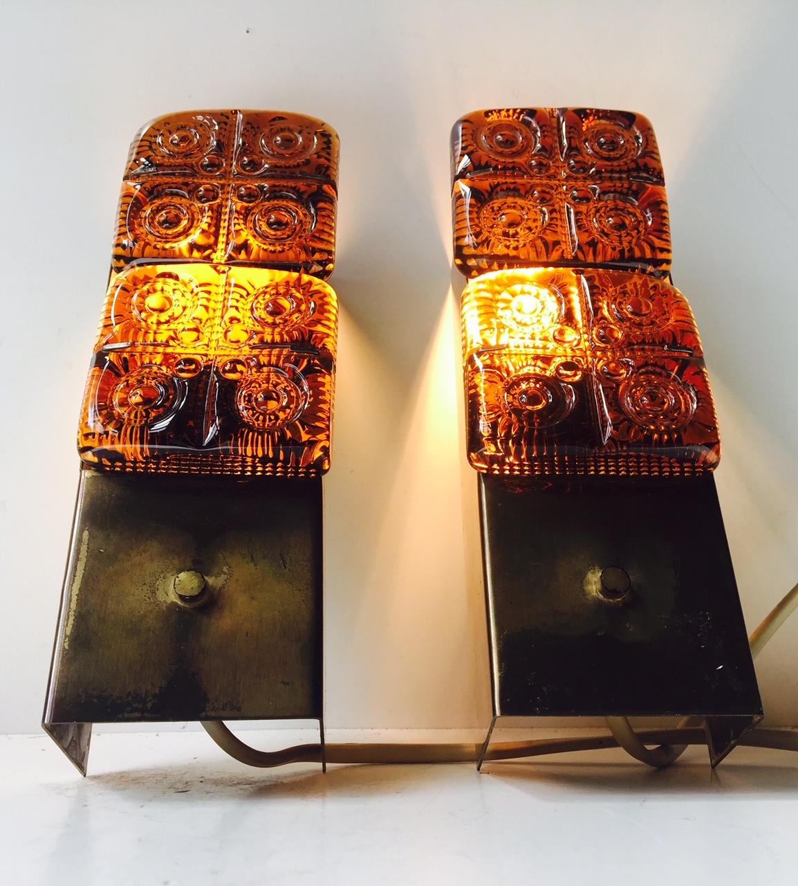 These wall lights from Austrian HAGS feature a solid brass construction with a rich rainbow-colored patina and thick amber glass inserts. Both stamped by the manufacturer.