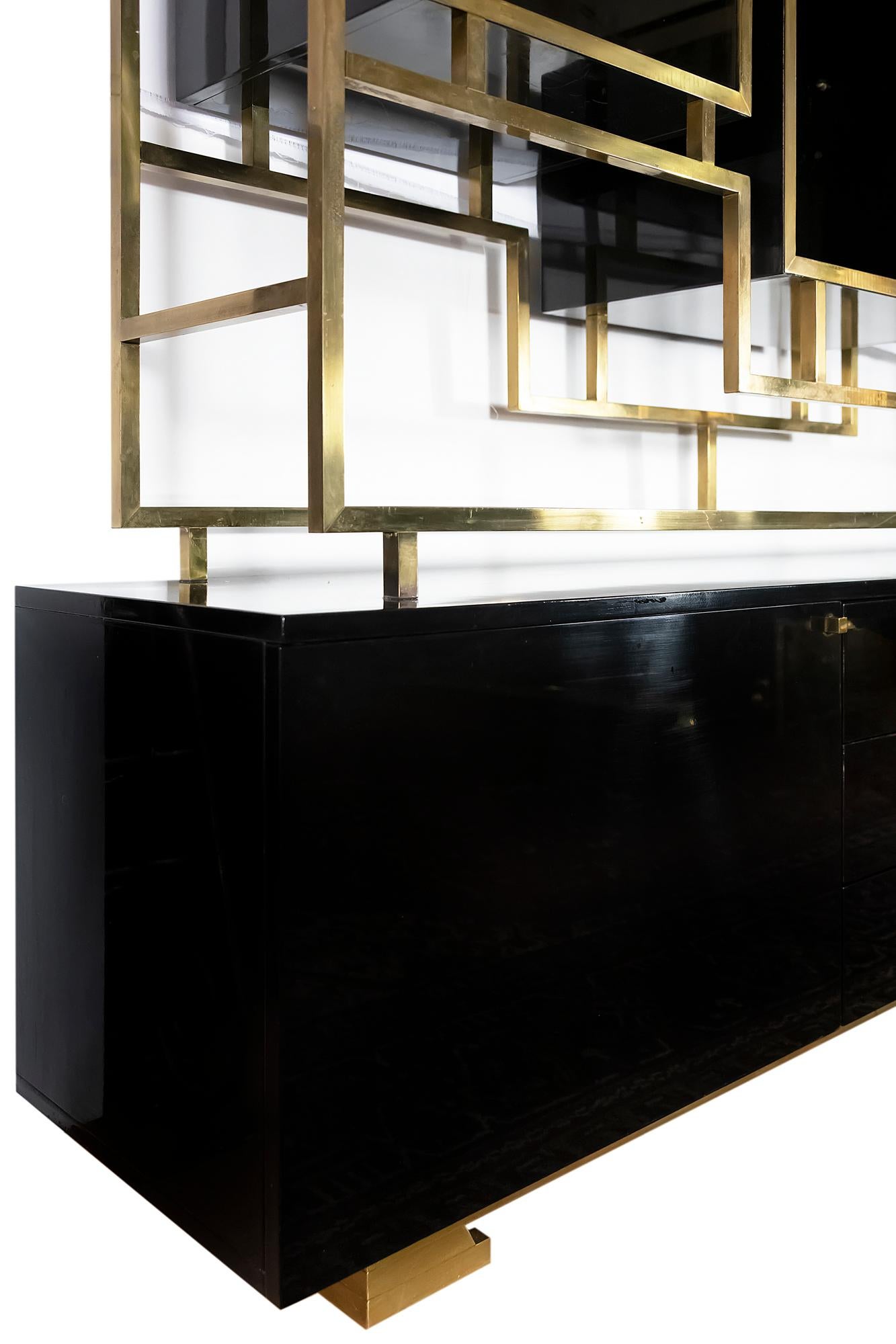 Midcentury brass étagère/sideboard/shelves by Kim Moltzer from 1970s.
This furniture consists of two parts: top structure in square brass and black lacquered wood with doors and shelves in black glass; bottom sideboard is on brass legs and in black