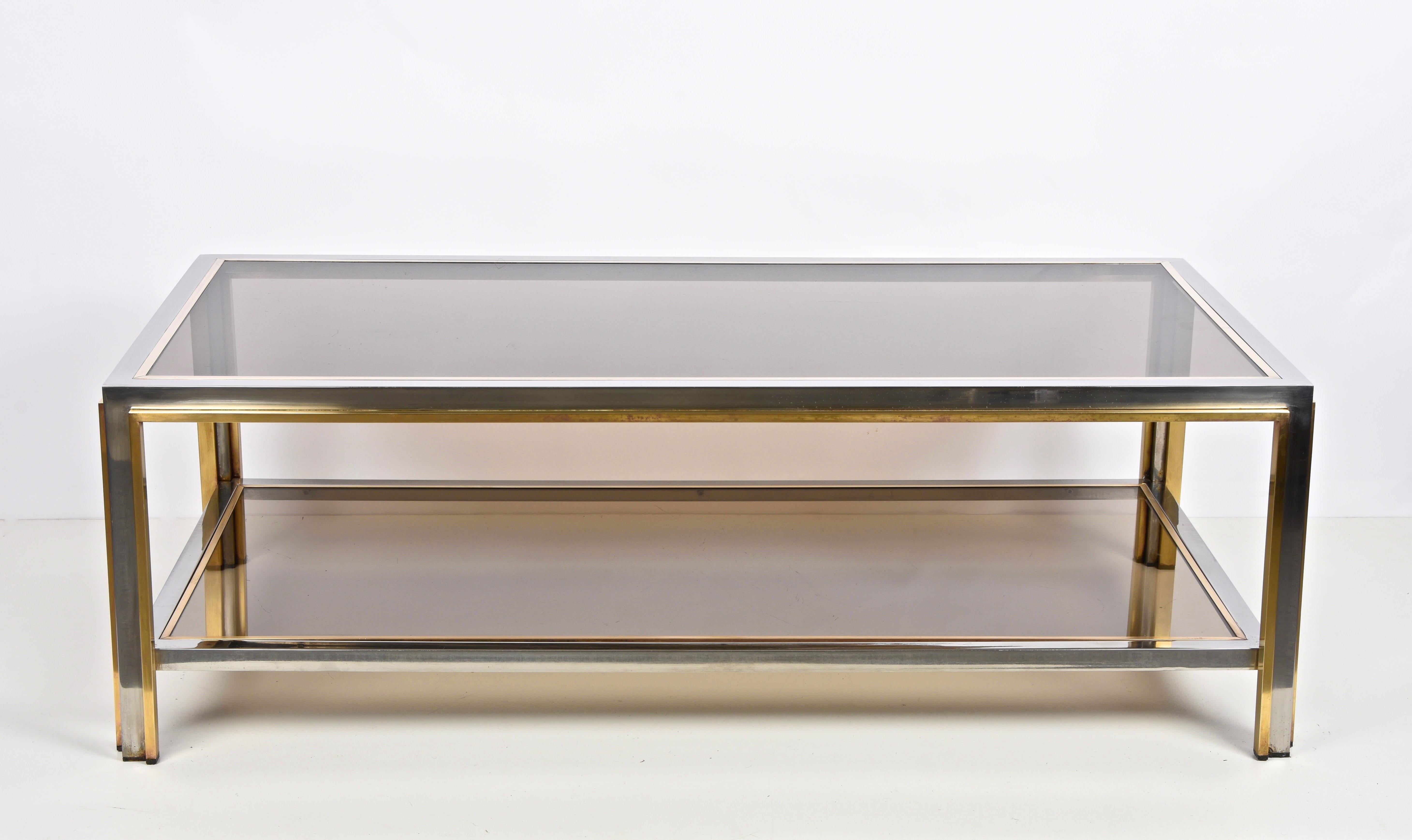 Amazing midcentury coffee table in chromed metal, brass and smoked glass. This wonderful piece was designed in the style of Romeo Rega in Italy during the 1970s.

The fusion of the three materials (chromed metal, brass and smoked glass) mix with