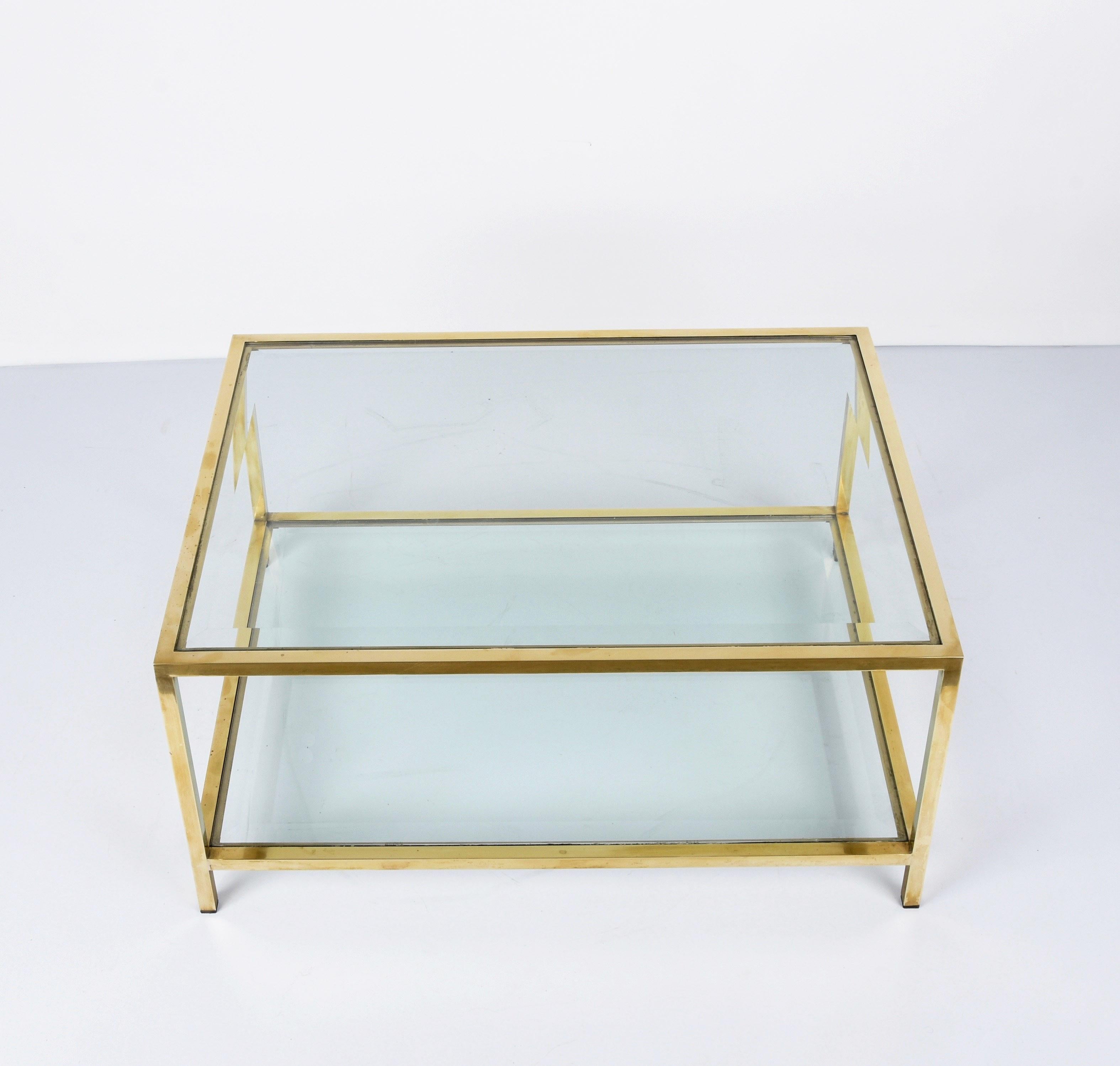 Amazing Mid-Century Modern rectangular coffee table with a brass structure and two-tiered glass tops. This fantastic piece was produced in Italy during the 1970s.

A luxurious item with a rectangular structure composed of straight lines and an