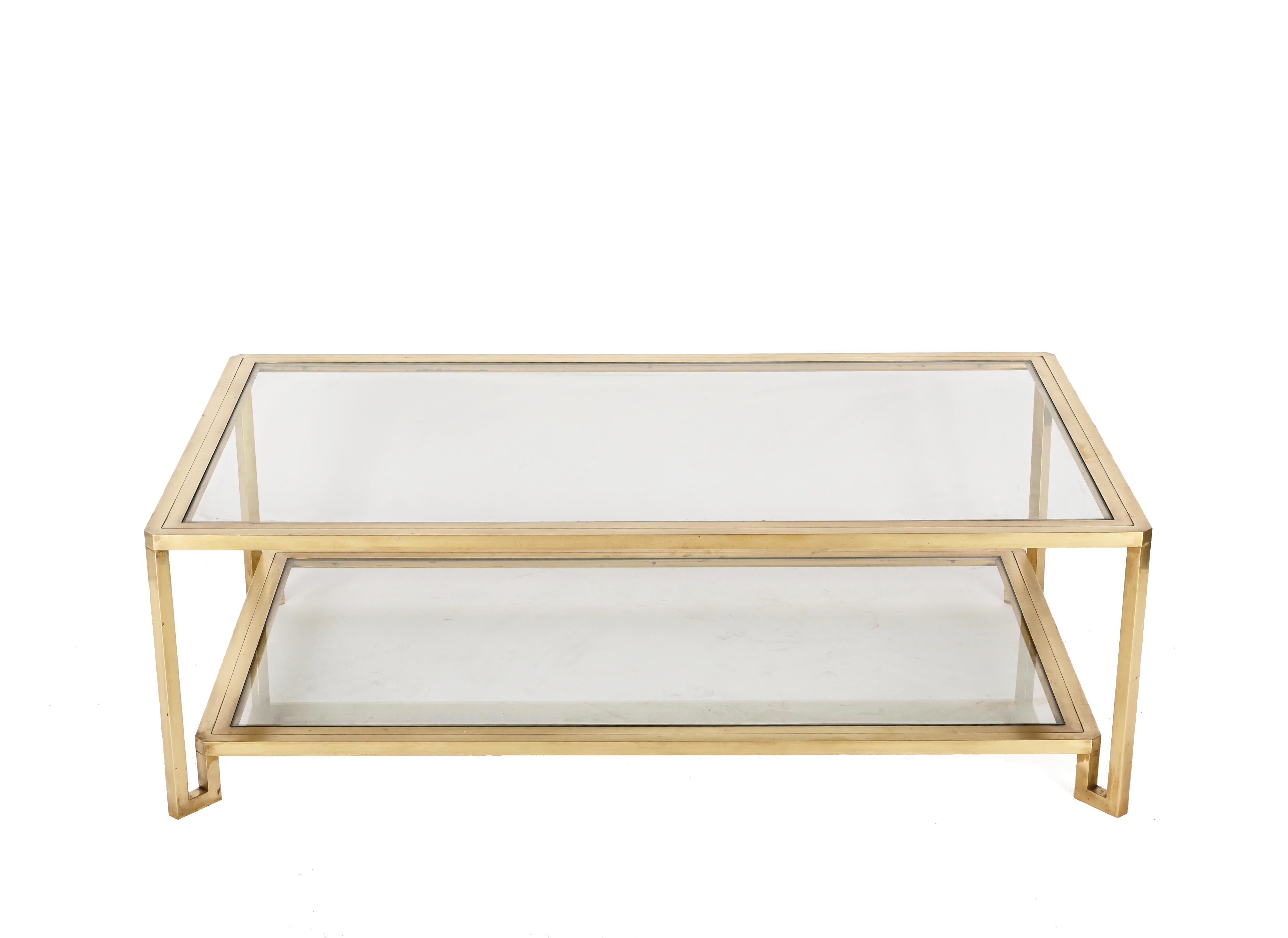 Unique midcentury modern rectangular coffee table with a brass structure and two tiers crystal glass tops. This fantastic piece was produced in Italy during the 1970s.

This luxurious item has a rectangular structure composed of a straight-lined