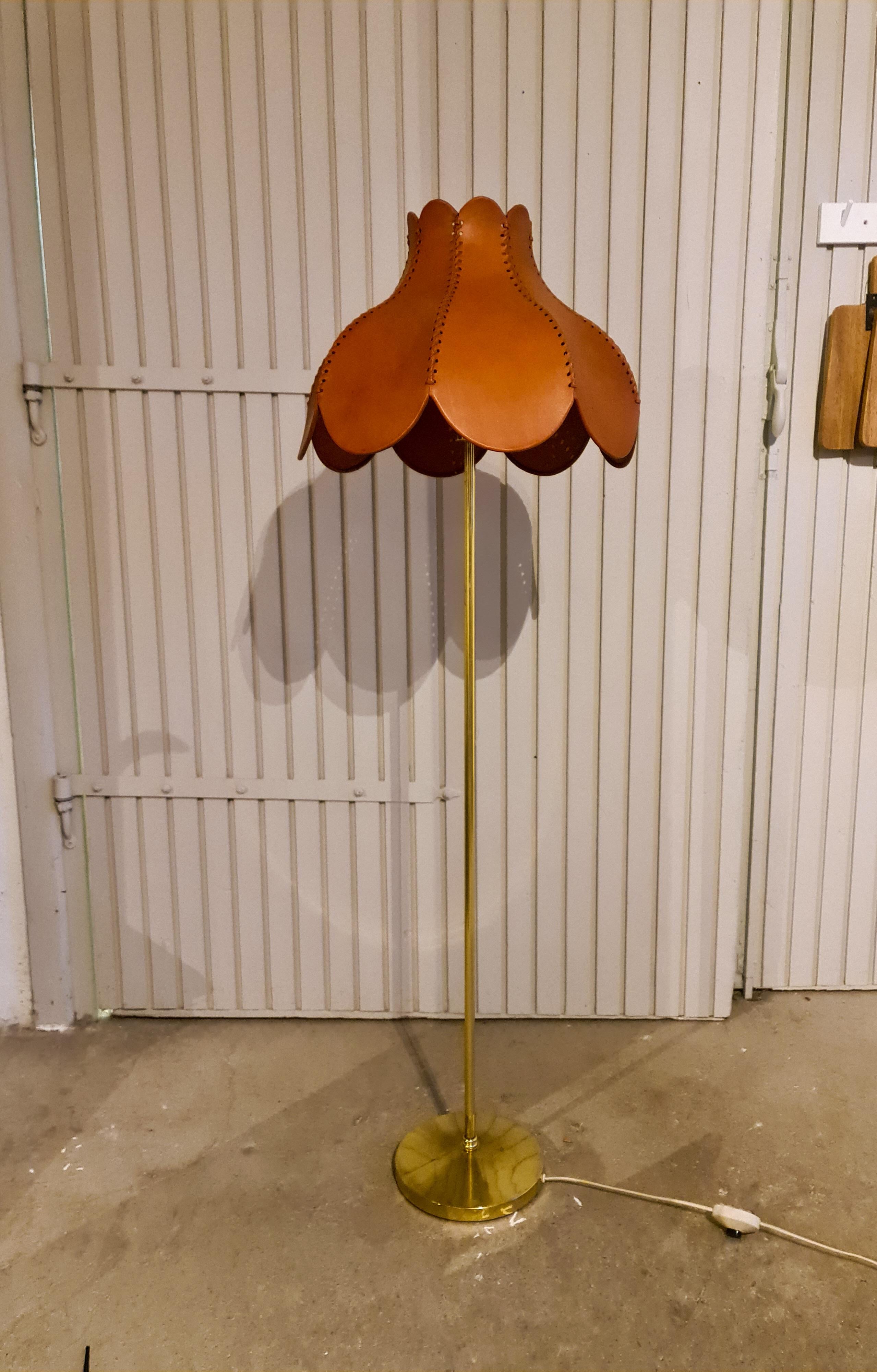Wonderful floor lamp produced in Sweden in the 1970s. Designed by Hans-Agne Jakobsson. This model has a solid brass stand with iron base and the lamp shade is made of leather with handcrafted stitches.

Good working condition, with some vintage