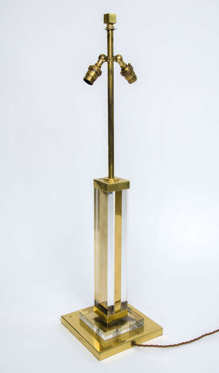 Elegant column table lamp of Lucite and brass, in Hollywood Regency style, with nice patina. European, second half of the 20th century (probably France, 1970s).

The lamp is in good vintage condition. It has a nice aged character, with some