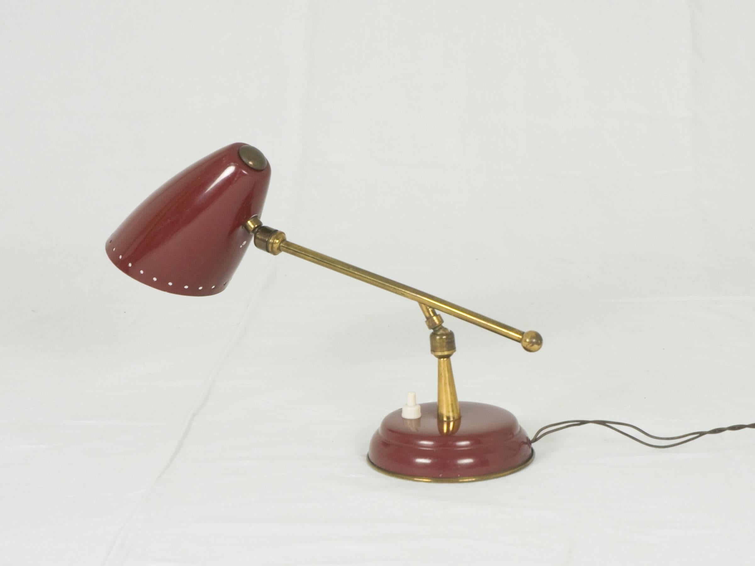 Small adjustable table lamp made from brass and painted metal. It remains in good vintage condition: slight deformation of the metal between the stem and the lampshade. Ideal as a bedside table or bookcase lamp.