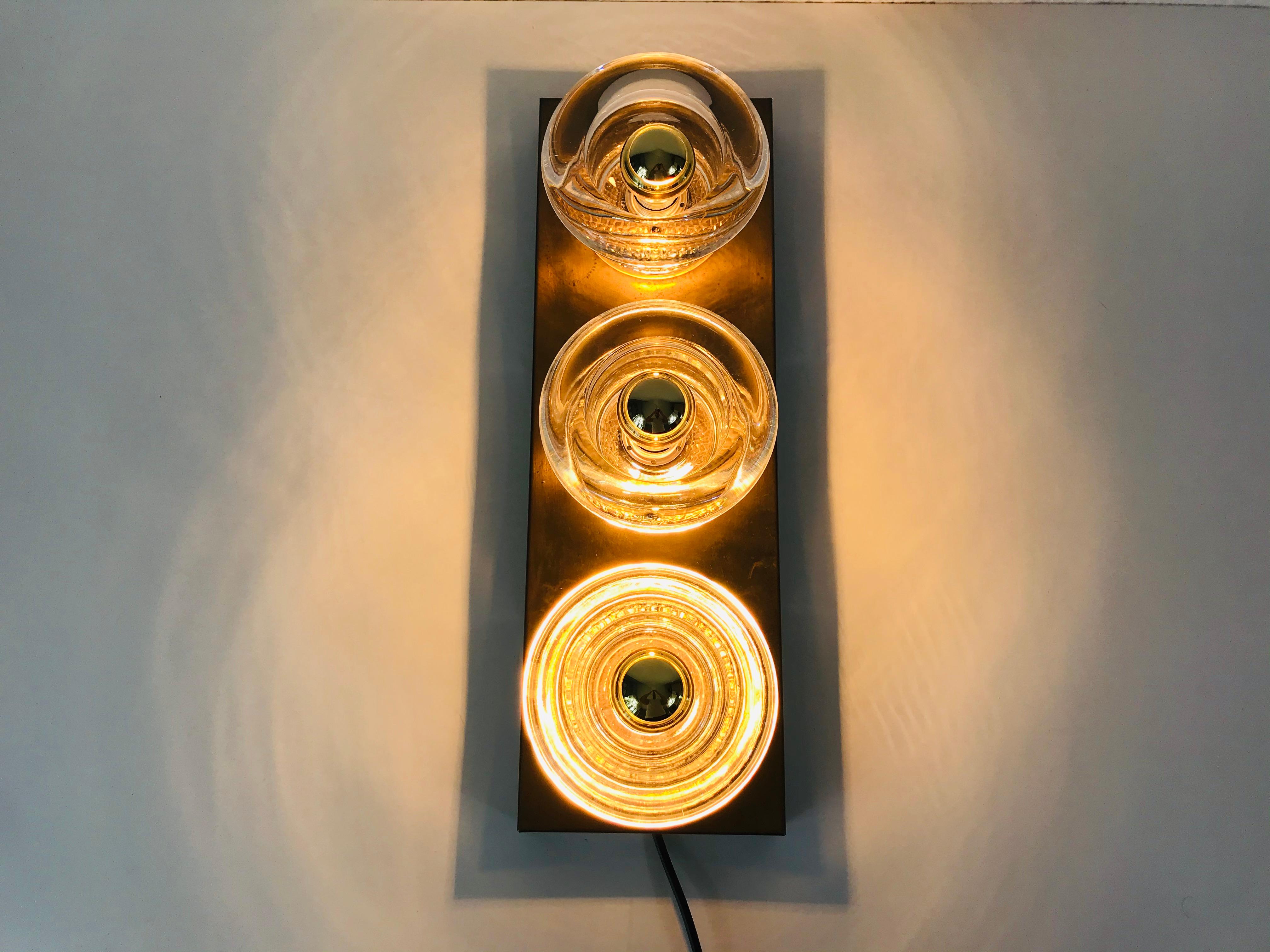 Midcentury beautiful wall light by the German brand Cosack made in the 1960s. It has three glass elements, each with one E14 light bulb socket. The unique glass shade is made from Murano glass.