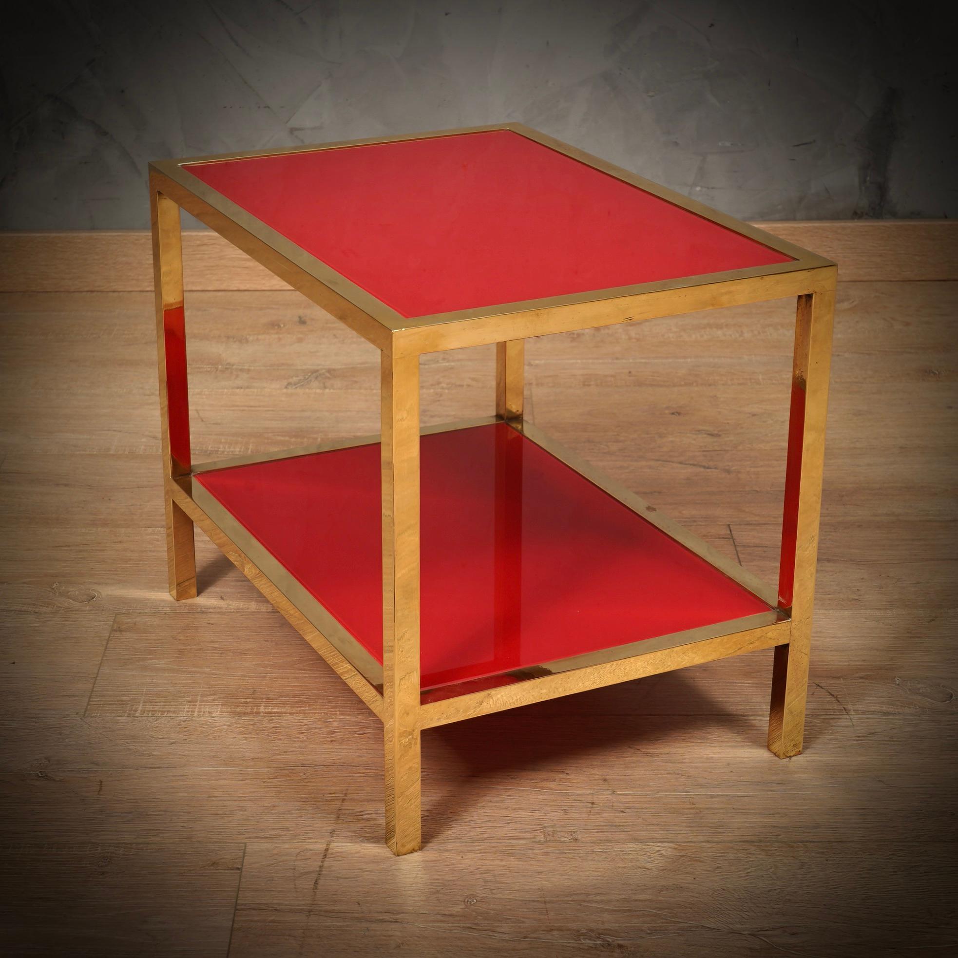 Exciting coffee tables in polished brass and red glass, linear but very elegant design, also due to the strong red colour. Simple but elegant workmanship for this coffee table, with thin legs and a beautiful color projecting it into a refined