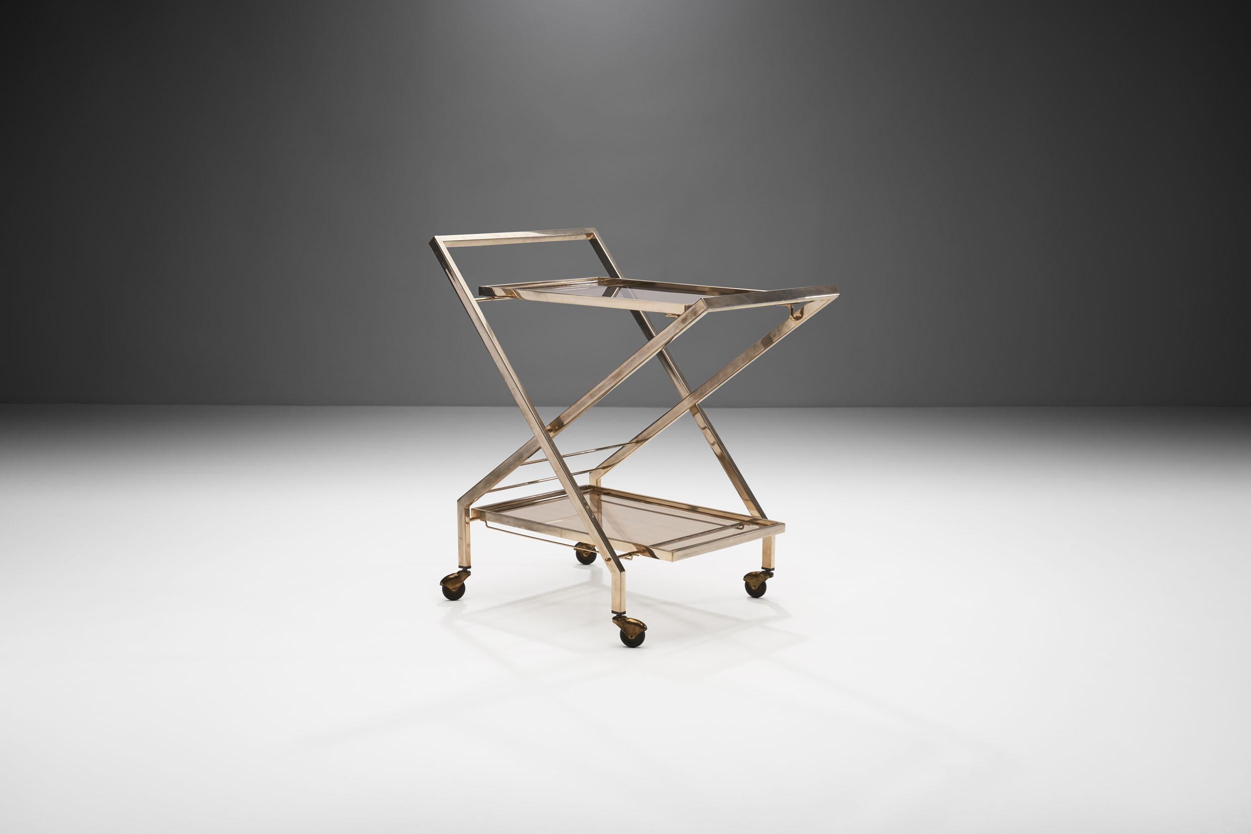 This Mid-Century Modern bar cart is a timeless and elegant piece, not to mention its functionality, 1960. The pairing of glass and brass is an elegant, modern combination of materials.

The two-tiered construction recalls the brass carts of the