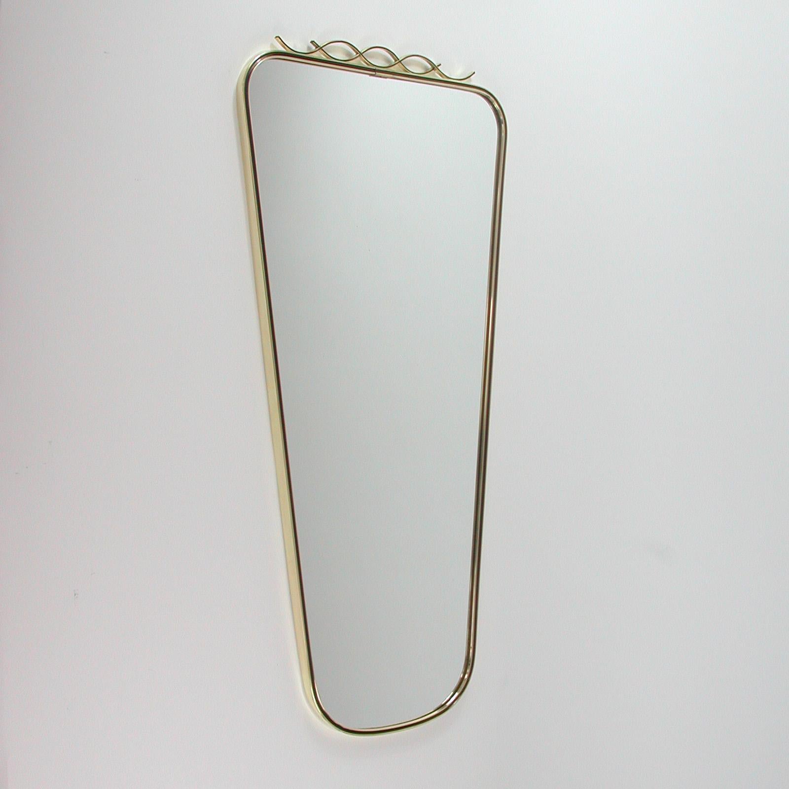 This beautiful rectangular midcentury wall mirror features a brass frame with black enamel decor and a looped brass finial. It was designed and manufactured in Germany in the 1950s by Münchner Zierspiegel (Münchner Zierform).

The mirror is in