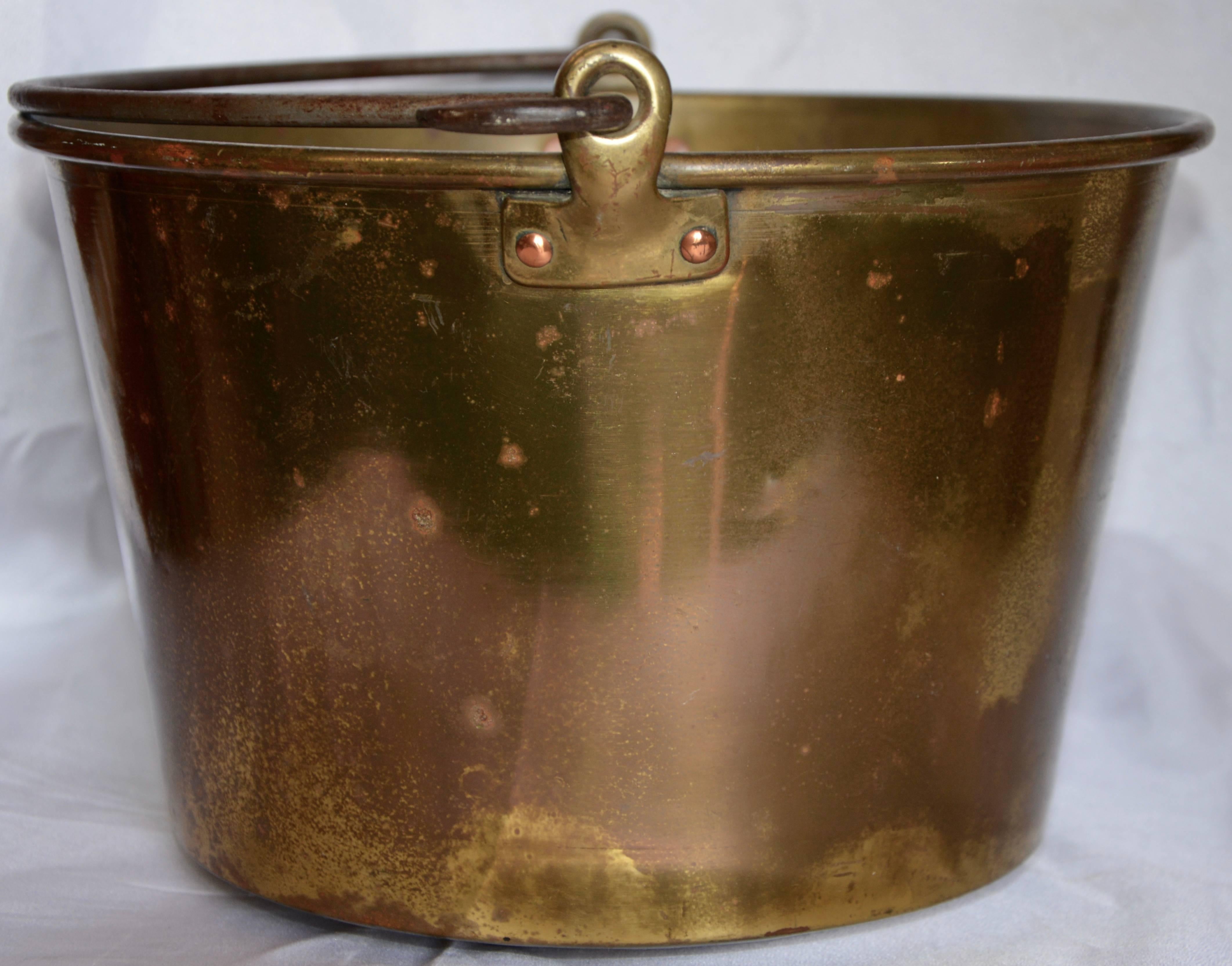 You can tell this brass bucket was used at some time for a special purpose. The dents on the bottom are attempting to tell a story. The cast iron handle is held in place with brass loops that are attached to the bucket with copper brads. This would