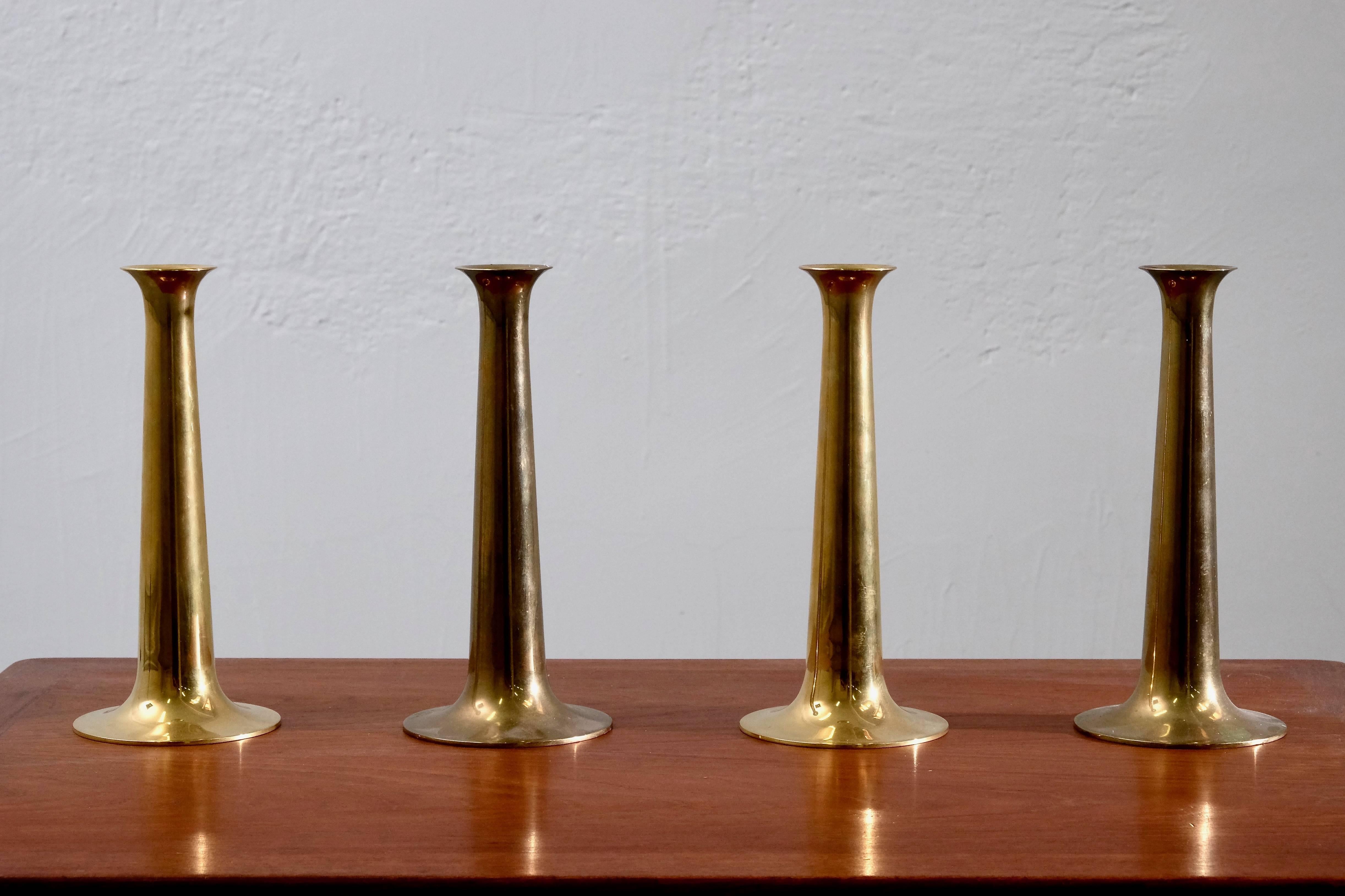 Set of four Danish brass candlesticks designed by Hans Bølling and manufactured by Torben Ørskov in the 1960s with manufacturer's mark on each base.