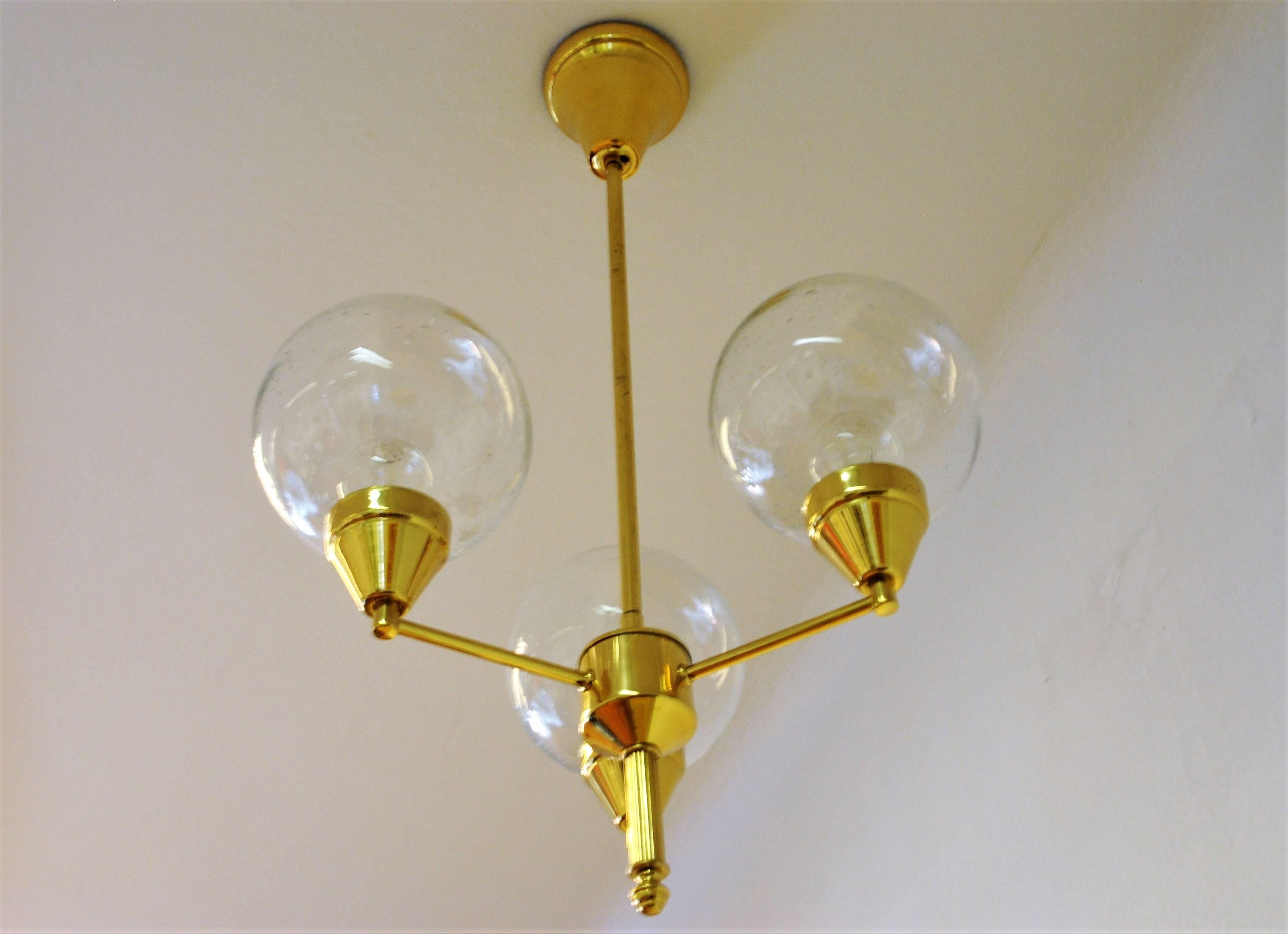 Ceiling lamp of brass and with three clear glass domes in upward position. Probably a Swedish lamp from around the 1960s. The glass domes have small enclosed airbubbles and are just to be put down in the glassdome holders. No screws needed. Size: 45