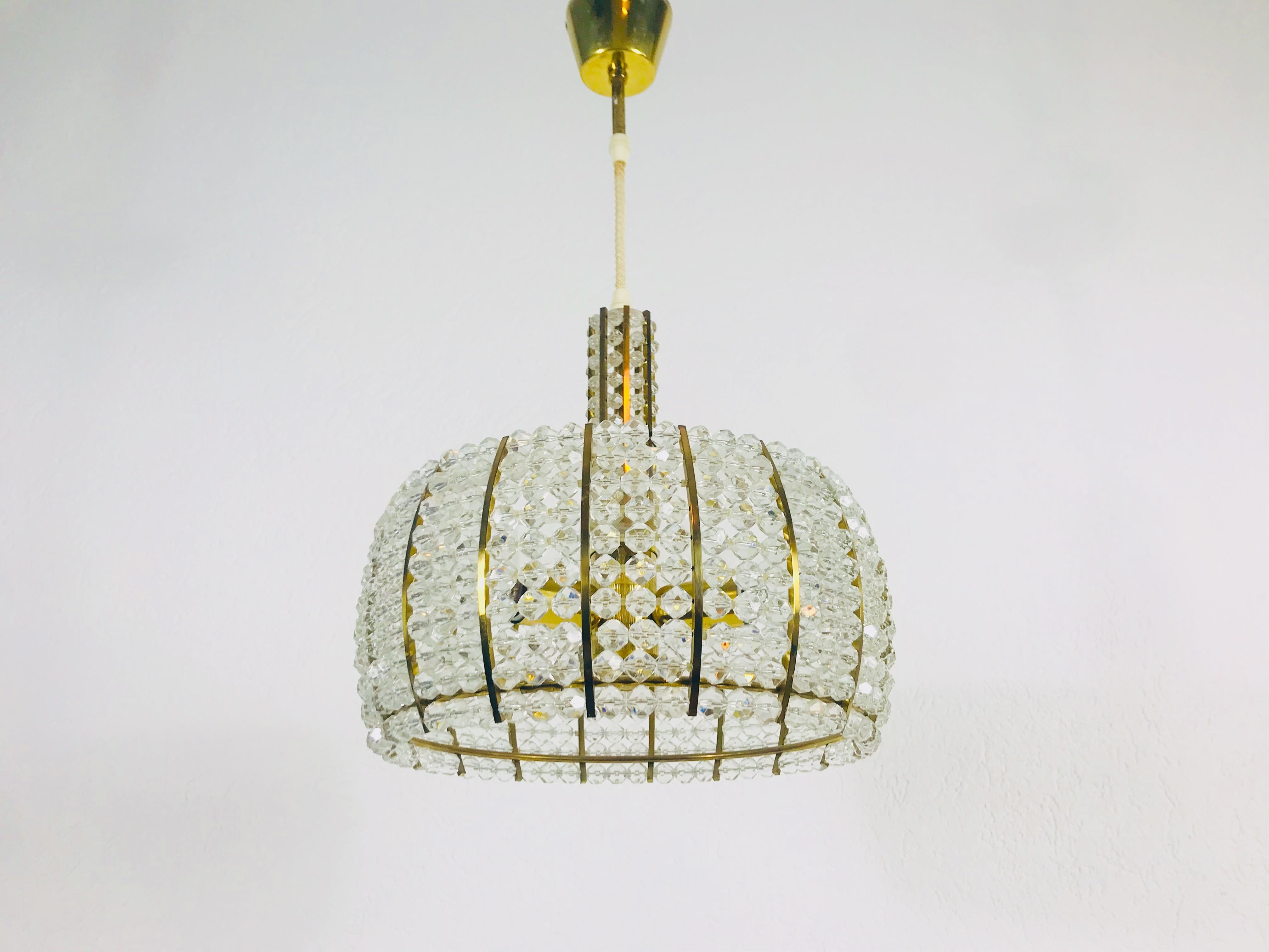 Un lustre en laiton réalisé par Emil Stejnar pour Rupert Nikoll, en Autriche, dans les années 1960. L'éclairage a un design midcentury étonnant. Elle est faite de laiton et de petits verres et s'intègre parfaitement dans un salon. Le luminaire