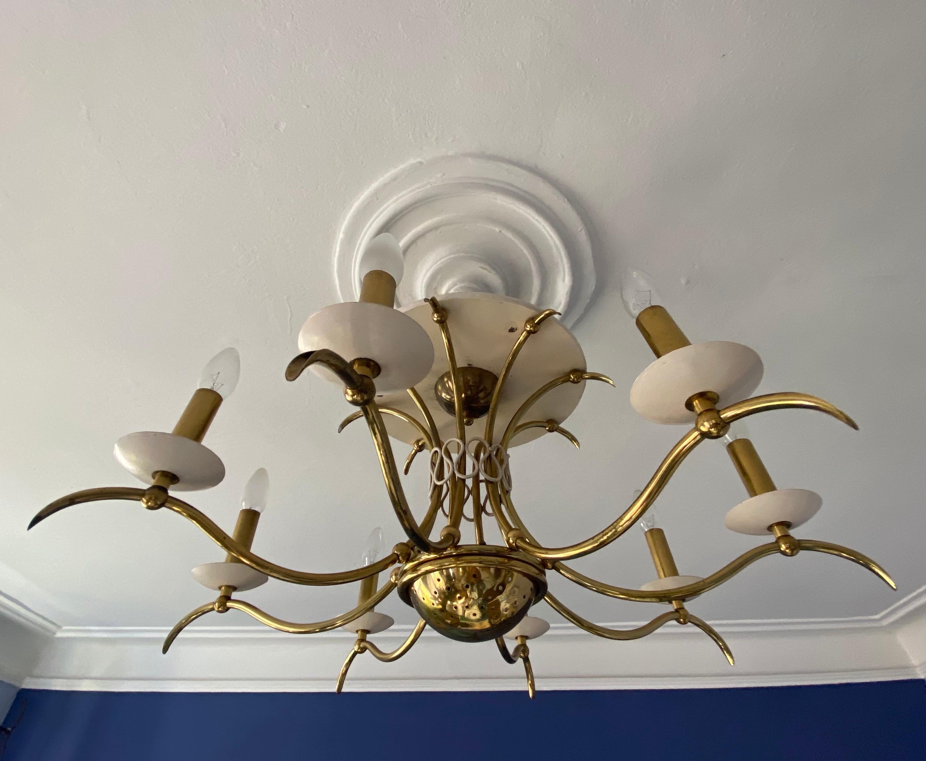 This Midcentury very elegant brass chandelier has in the middle of the structure an integrated small perforated Uplighter to create a really beautiful light distribution.
It was designed in the early 1950s to mount alternatively directly on a