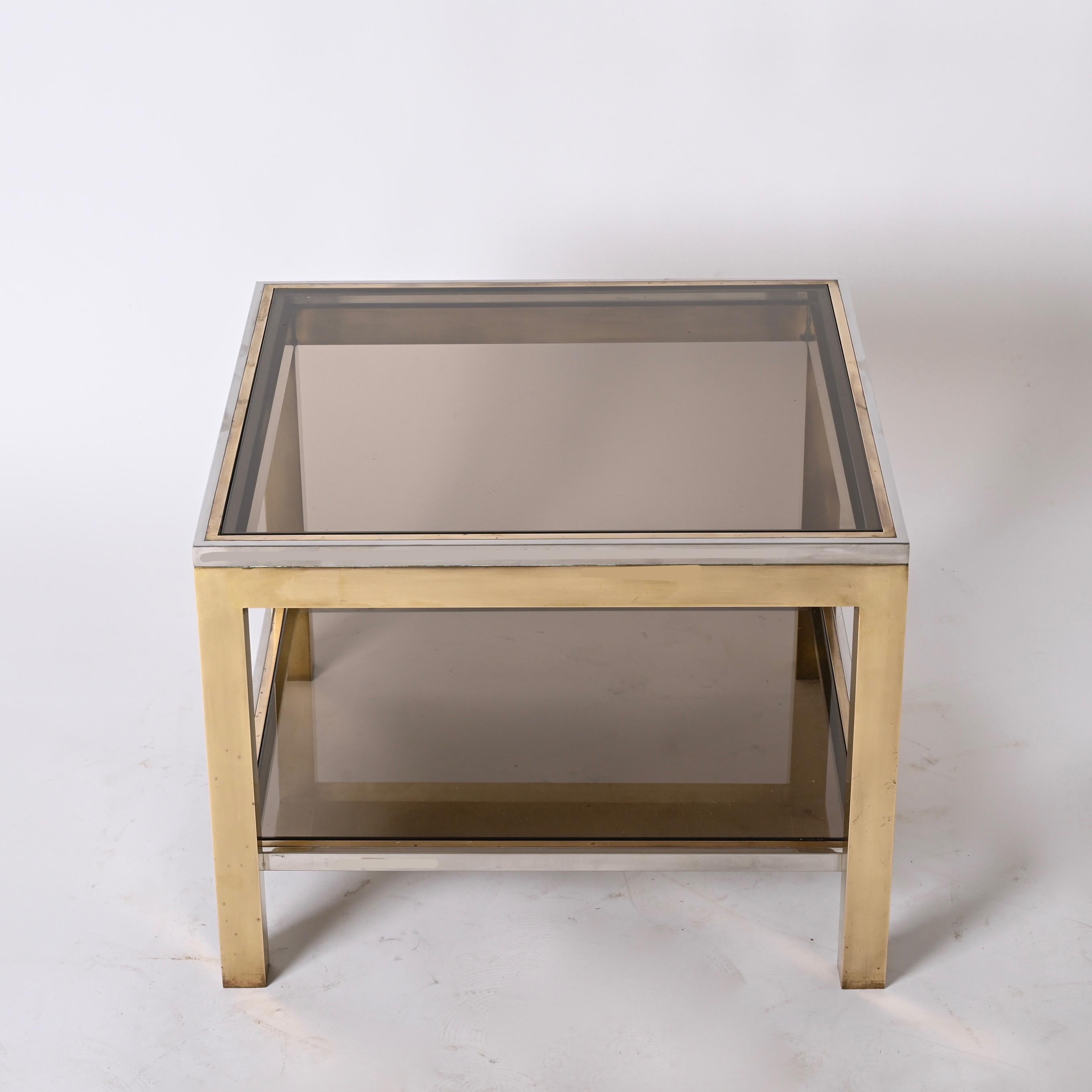 Amazing midcentury coffee table in chromed metal, brass and smoked glass. This wonderful piece was designed in the style of Romeo Rega in Italy during the 1970s.

The fusion of the three materials, chromed metal, brass and smoked glass, plus the