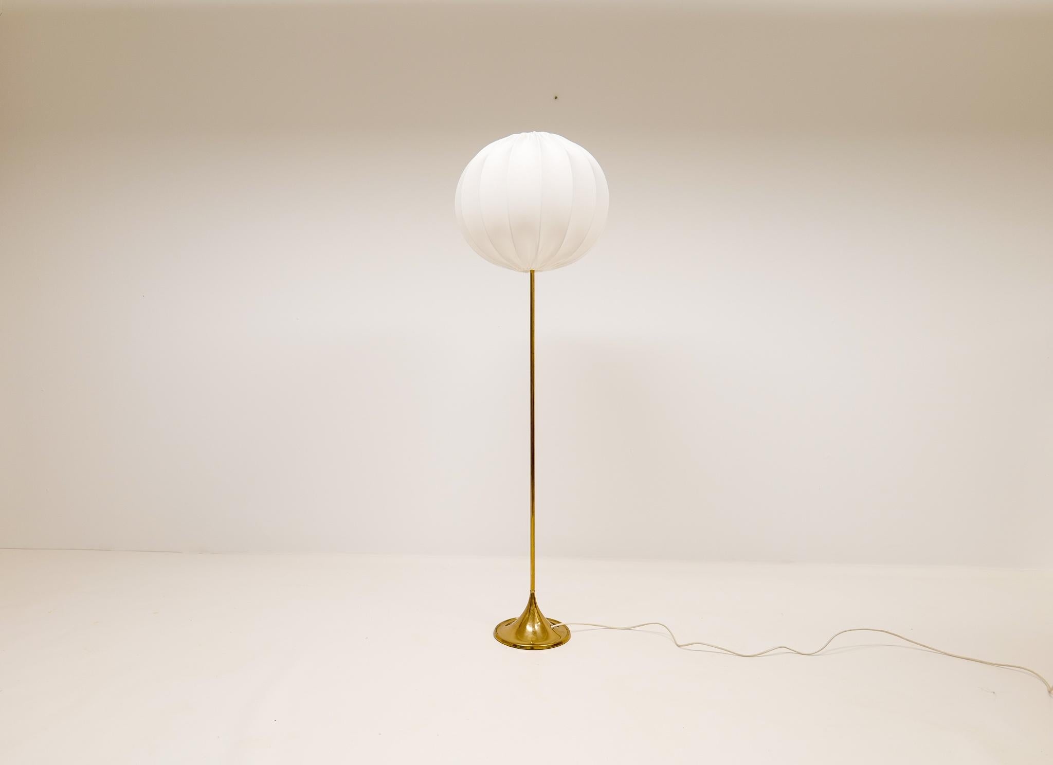 Nicely designed floor lamp from Bergboms Sweden. Made in brass and cast iron. They were made in the 1960 and have a nice, shaped trumpet foot. This one come with brand new cotton shade made in Sweden. This one is the small size floor lamp and could
