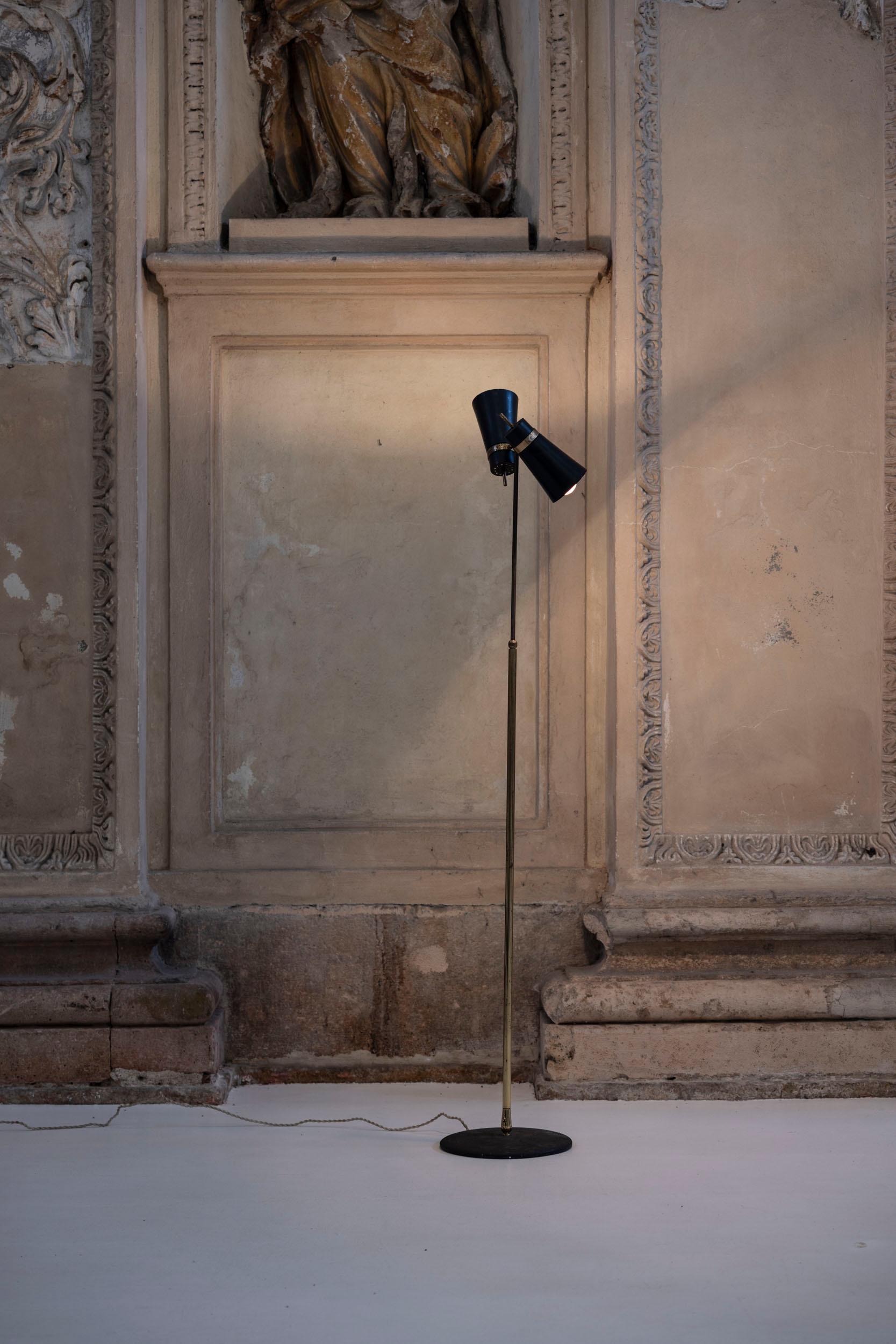Elegante lampada da terra in ottone di metà secolo, disegnata da Giuseppe Ostuni per Oluce in Italia negli anni '50, incarna la raffinata semplicità e il fascino senza tempo del design moderno di metà secolo. La lampada presenta una base circolare