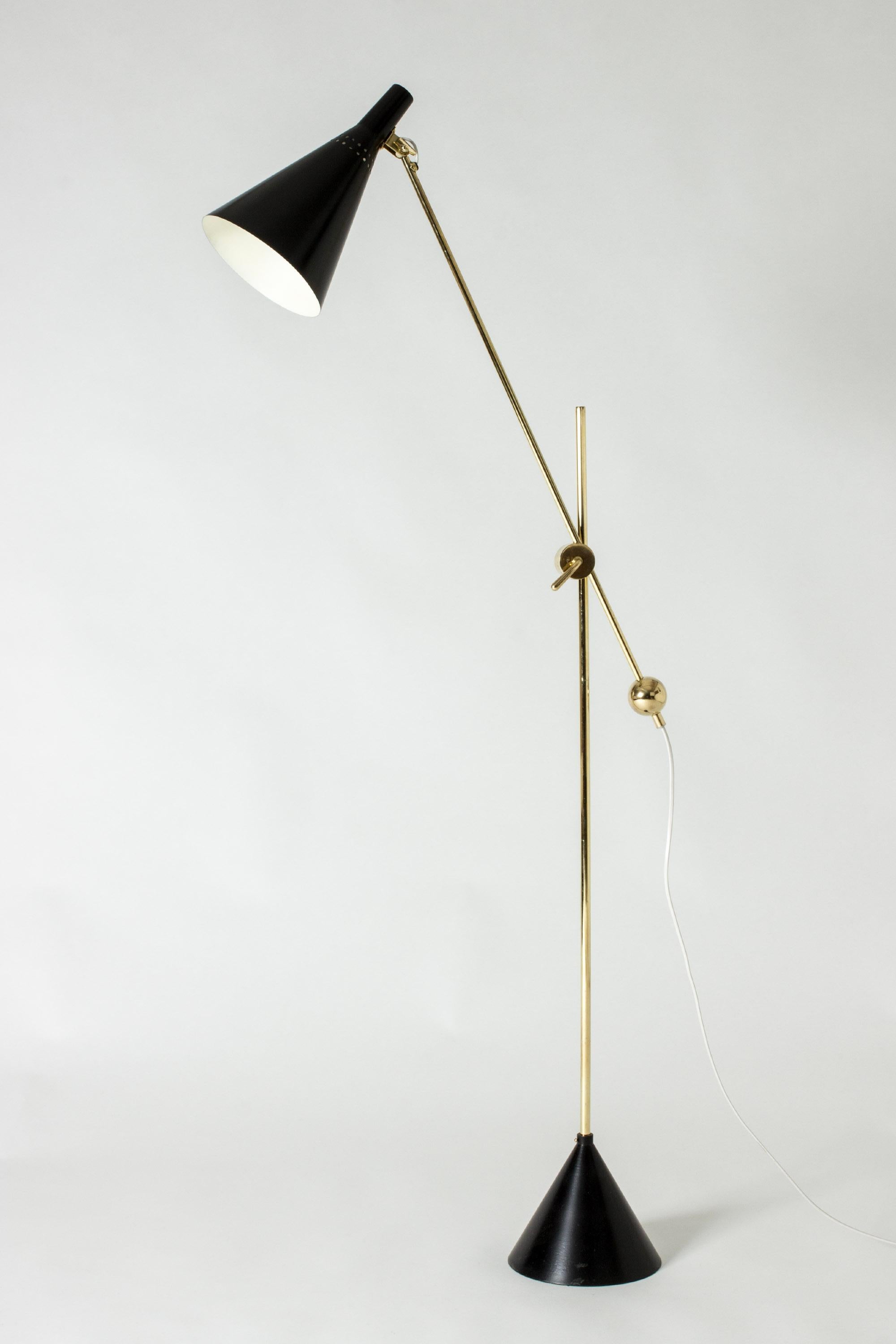 Amazing floor lamp by Tapio Wirkkala, made from brass and black lacquered metal. Beautiful decorative brass details and clever mechanism for shifting the height and angle of the shade. Conical base.