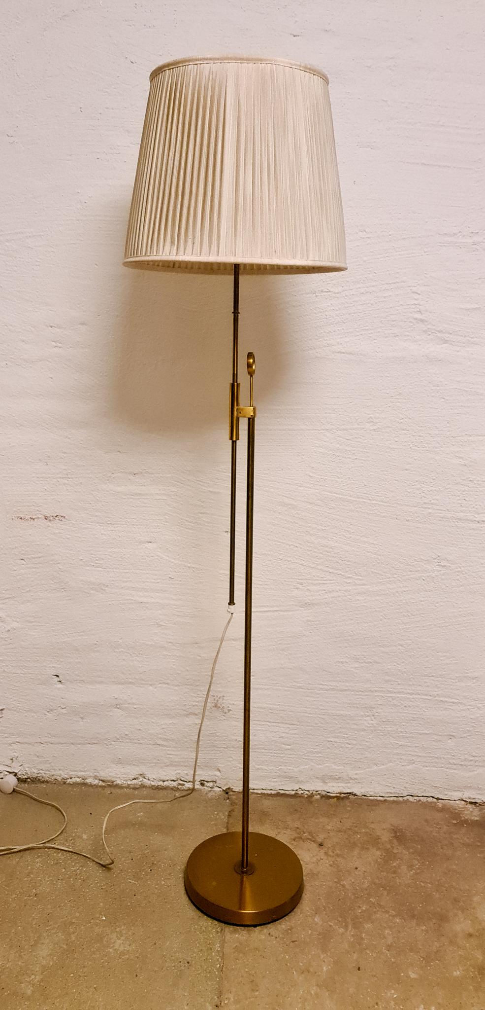 This lamp was made in Sweden at Falkenbergs Belysning. Wonderful, assembled brass combination with adjustable height. Nice additional art deco brass detail with the ring attached to the middle of the lamp. 

Good working condition. Original shade,