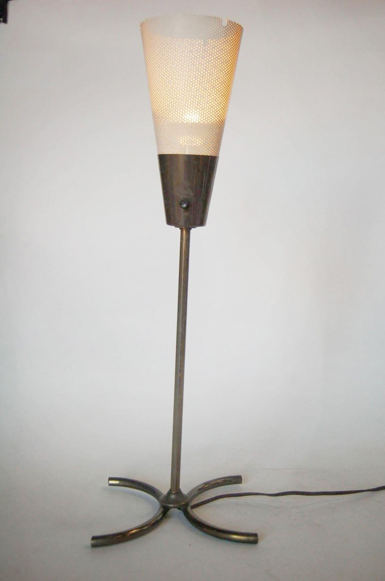 Unique Googie brass and white enamel freestanding torchiere table lamp with perforated cone shade.

Measures: 8