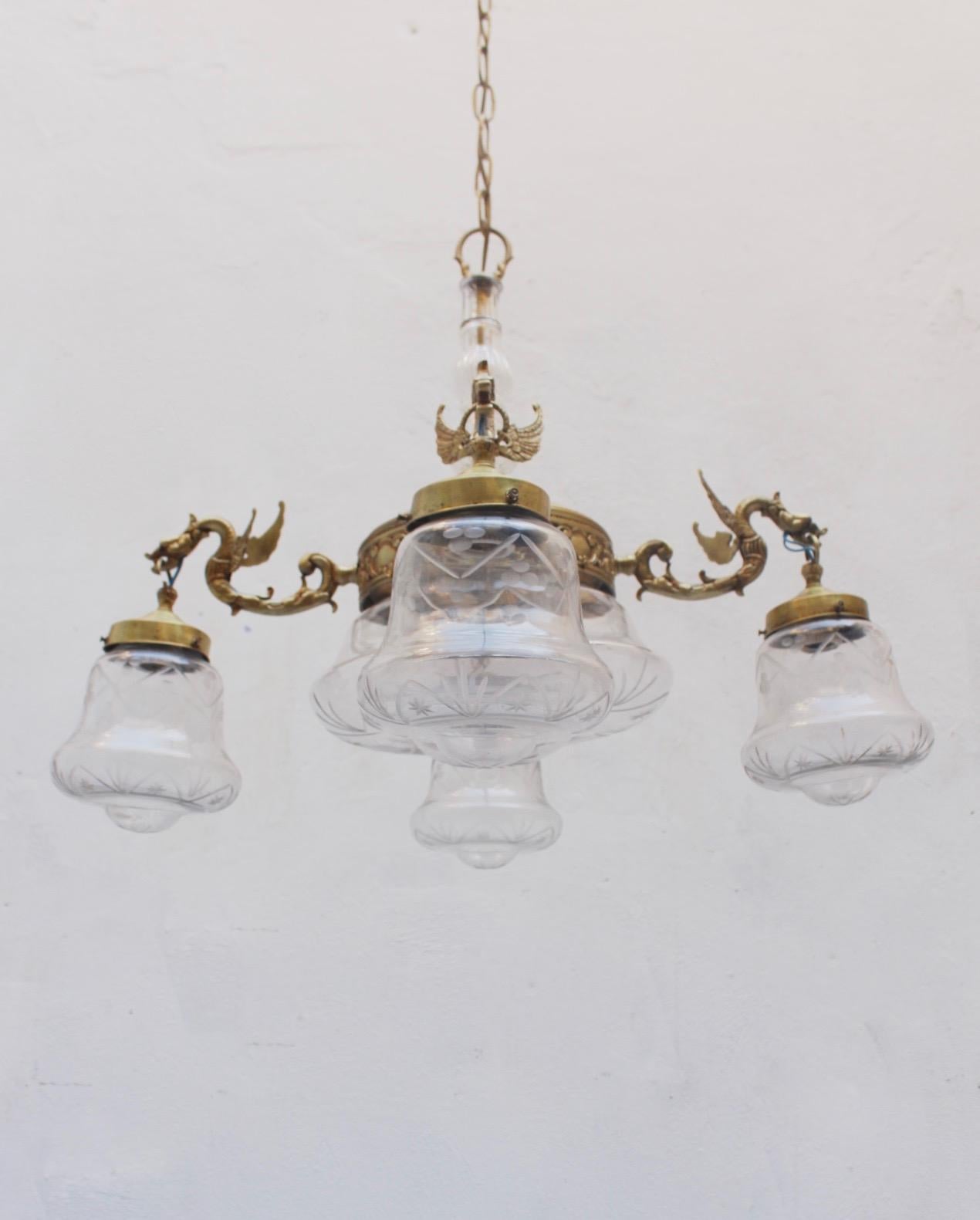 Midcentury brass and glass five lights dragon chandelier, 1950s.

Measures: Chains length: 63 cms.