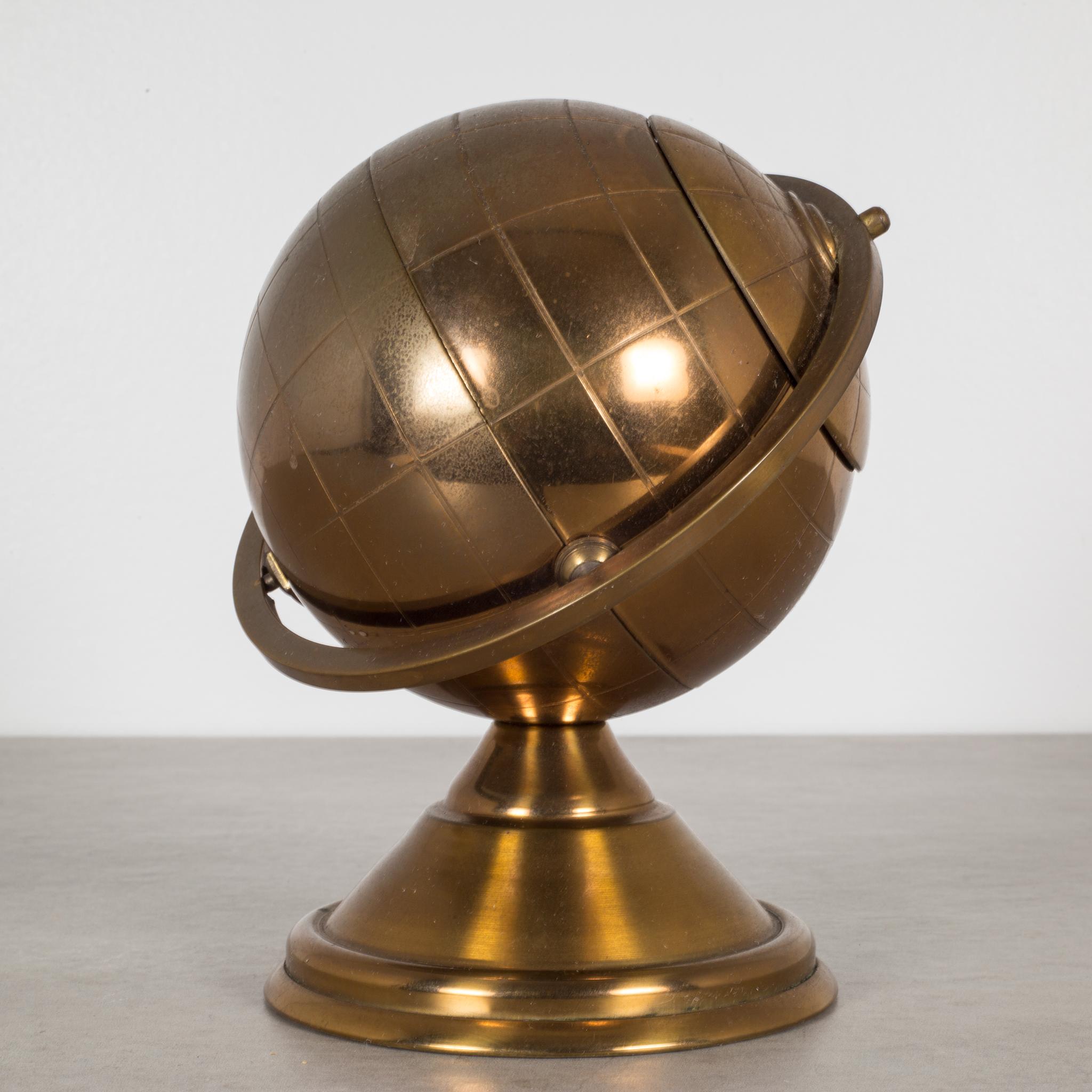 About

This is an original midcentury brass cigarette holder. The lid slides open on the globe's axis to reveal a metal interior designed to hold cigarettes.

This piece has retained its original finish and has the appropriate finish for the age