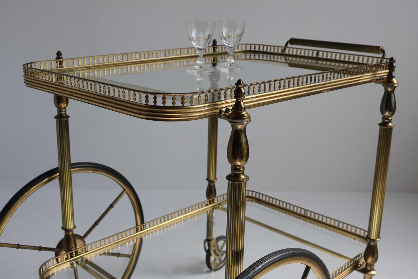 Large wheels bar cart midcentury golden brass serving trolley cocktail entertainment beverages tea cart clear glass Hollywood Regency, 1960s

Beautiful entertainer’s bar cart with two large wheels at one end.
Great for displaying your bar set, or