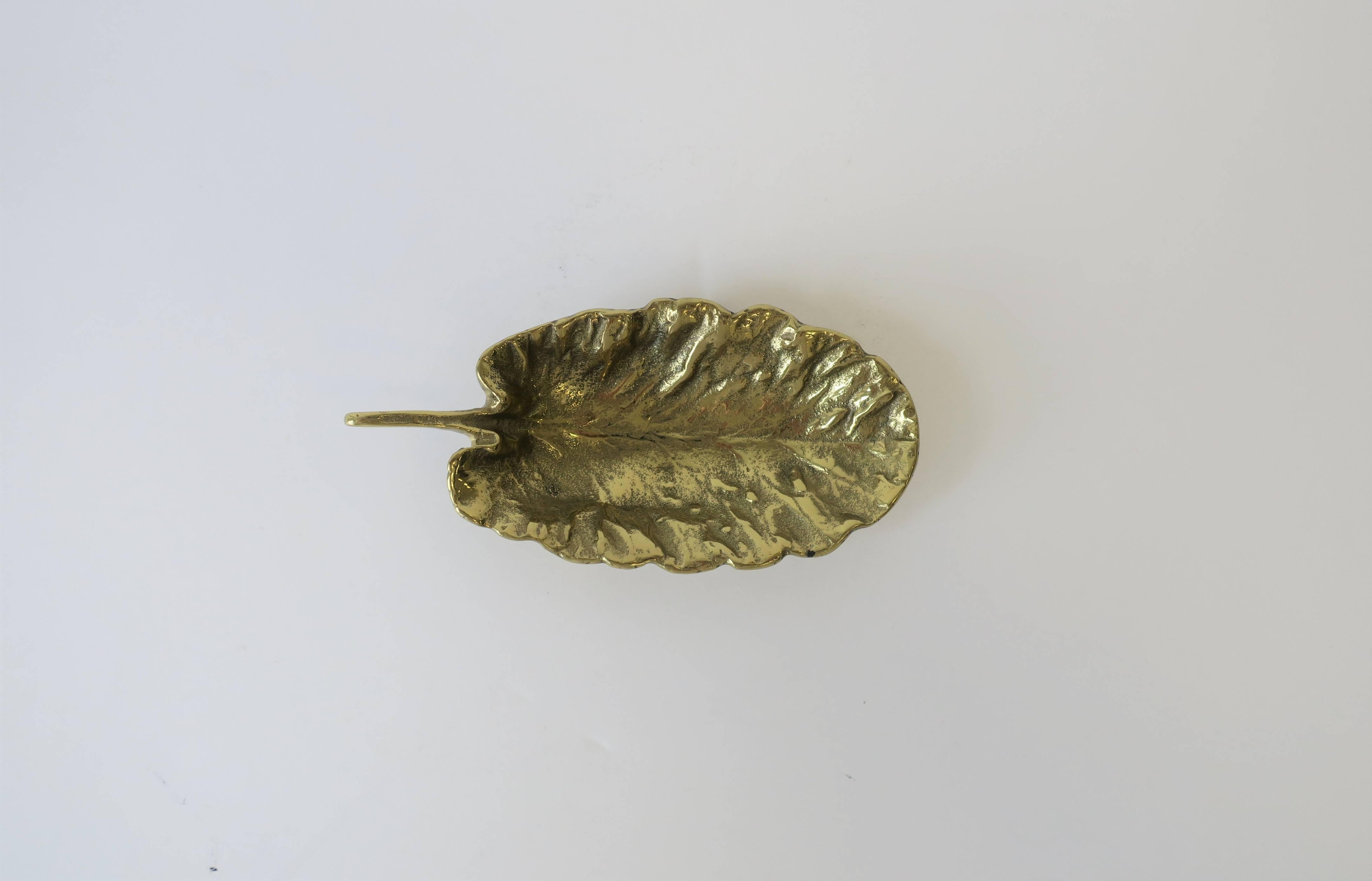 A small and substantial solid brass leaf form decorative or jewelry dish, circa mid-20th century; Made 1956. Beautiful as a standalone piece, for jewelry, or small items on a desk, vanity, nightstand table, walk-in-closet, etc. Piece is marked on