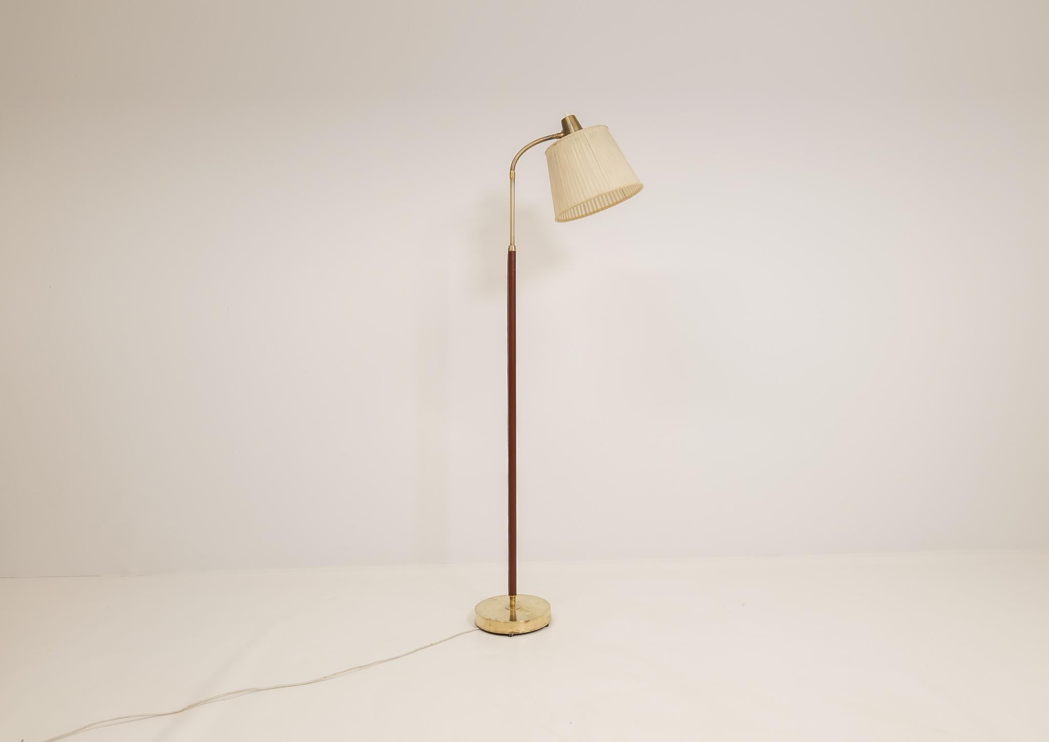 This lamp was made in Sweden at Falkenbergs Belysning. Wonderful, assembled brass combination with leather rod. The brass working well together with the brown stitched leather.

Good patinated brass, working condition. Original shade with some