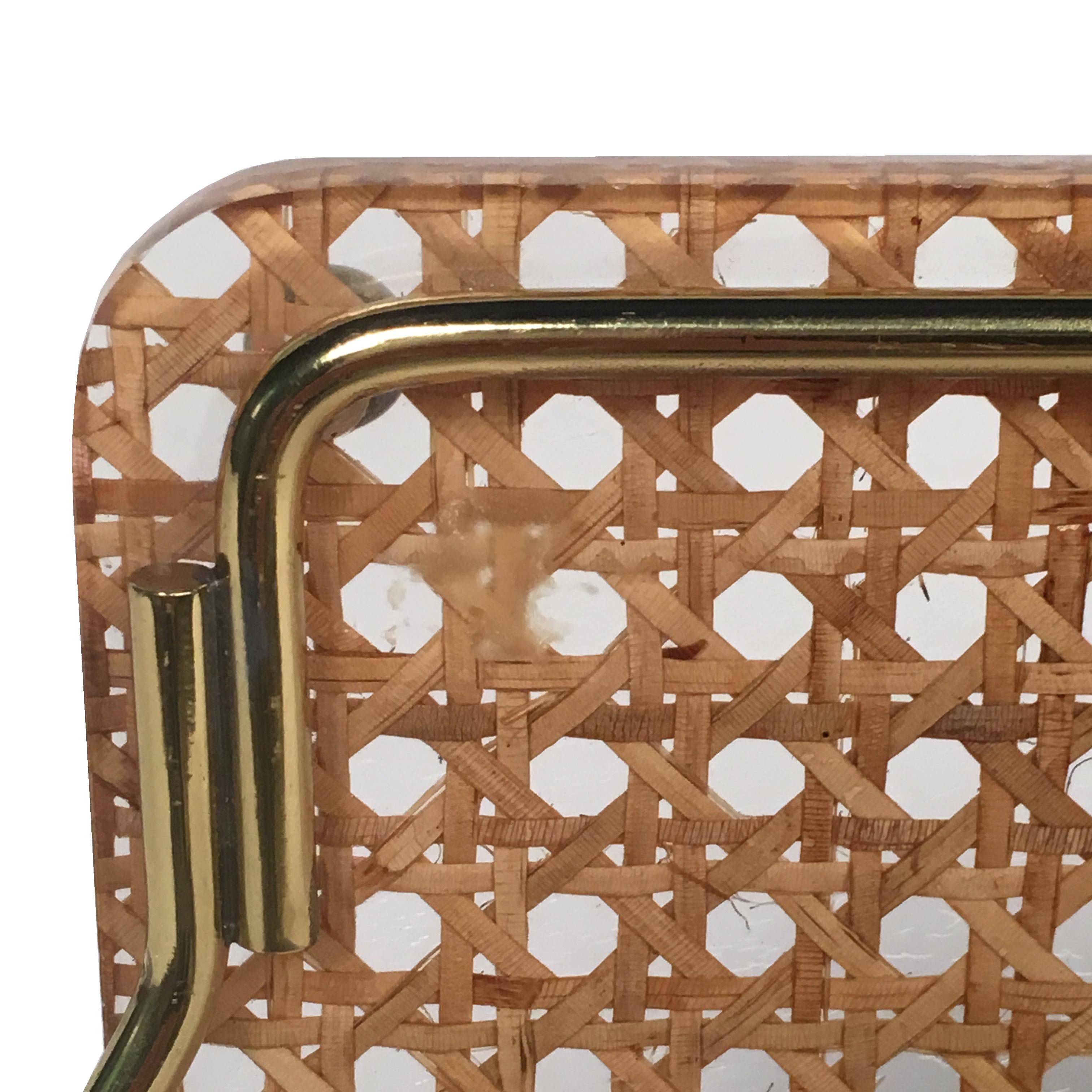 Midcentury stylish butler serving tray made of Lucite and rattan, designed for Christian Dior Home collection in 1970s.
The item has a rectangular shape with gilt brass edges and grips and real rattan cane-work embedded in the crystal clear