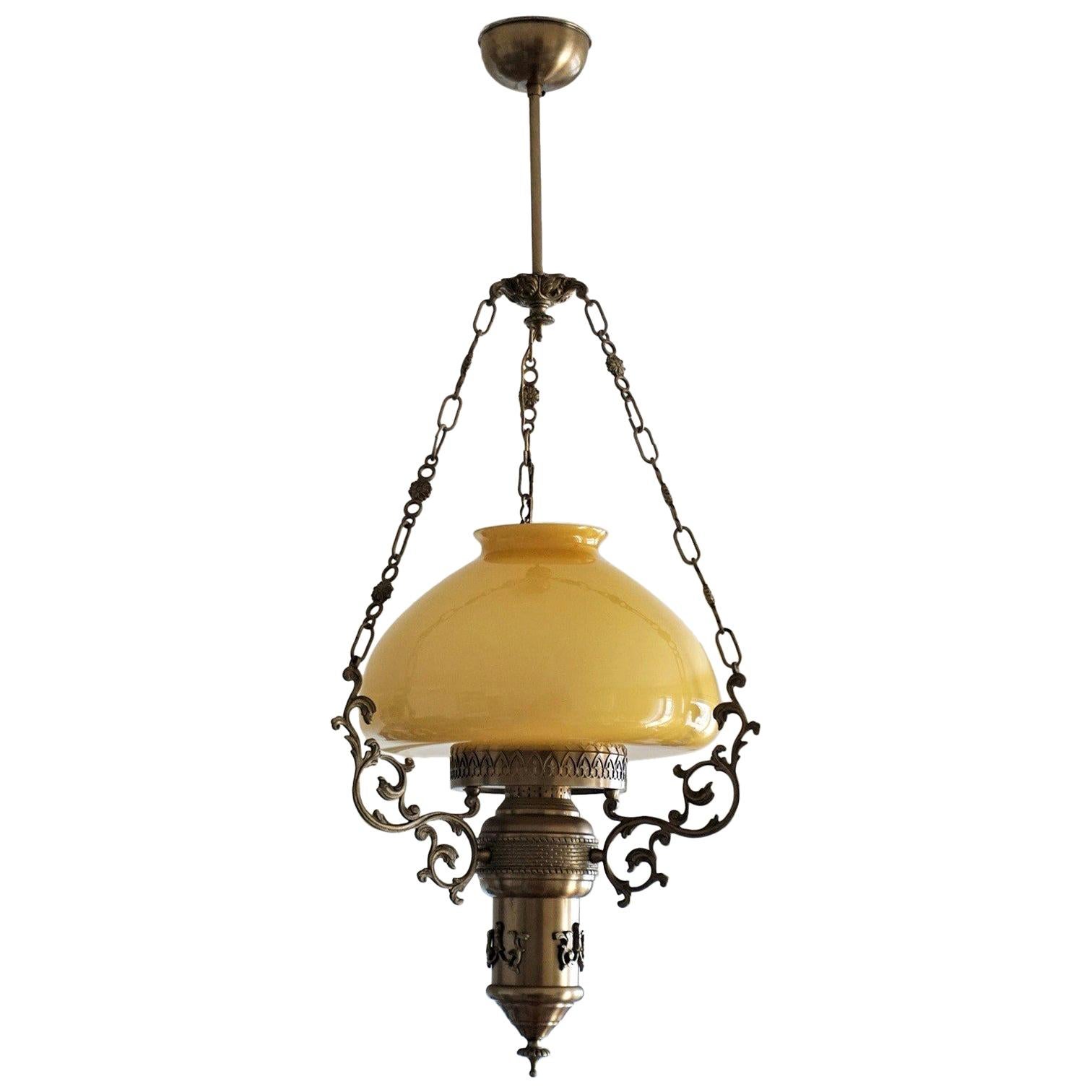 Lanterne de suspension en laiton bruni et verre opalin de style Art Nouveau, vers 1950. Trois chaînes de suspension en laiton reliées à un dais décoratif. Une haute cheminée en verre transparent est incluse.
Un support d'ampoule E27.
Mesures