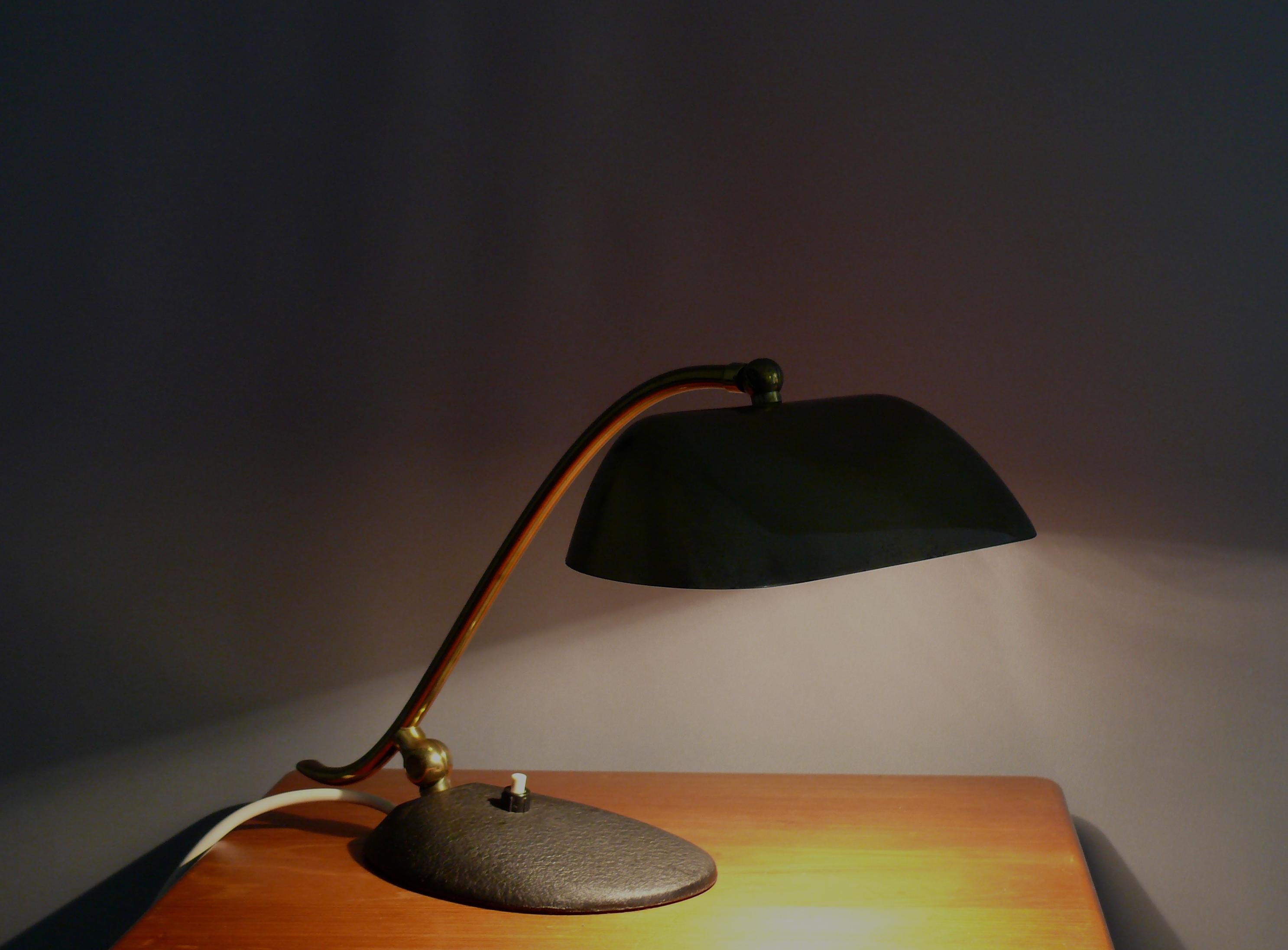 Très solide et rare lampe de piano en laiton des années 1950 - 1960. Il s'agit d'une lampe de l'entreprise Joseph Brumberg de Sundern. La lampe est fabriquée en laiton avec une base en métal lourd recouverte d'une laque noire rétractable. La lampe