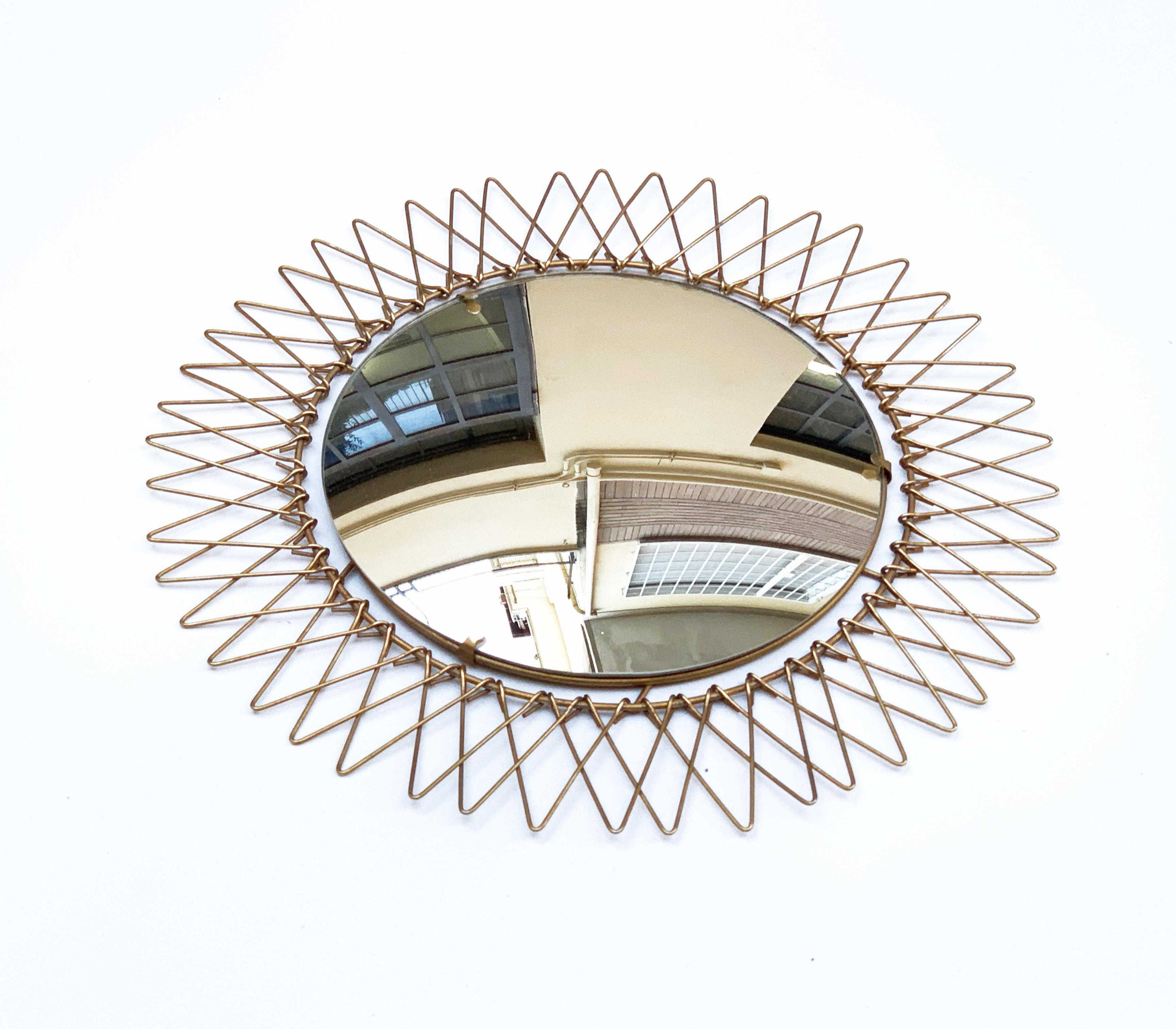 Elegant French sunburst-shaped mirror, produced in France during the late 1970s. 

This amazing round wall mirror has a brass wire frame, adjustable both inward and outward.

A splendid piece that will give light and deepness to a midcentury