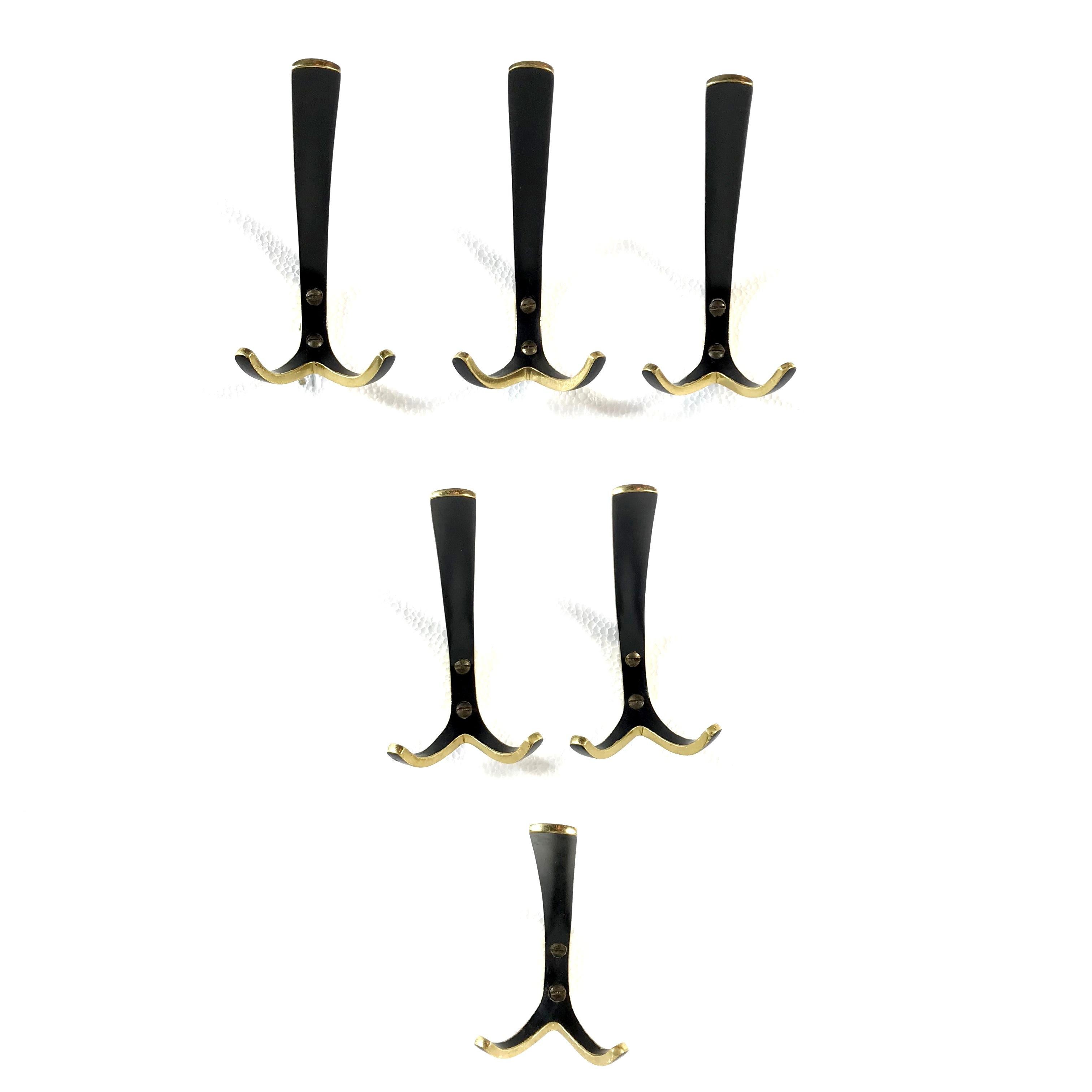 Beautiful Austrian midcentury solid brass hooks by Hertha Baller from 1950s. They are in the style of Auböck and competed with Auböck in their time. They are made of polished solid brass partly black lacquered and come with the original brass