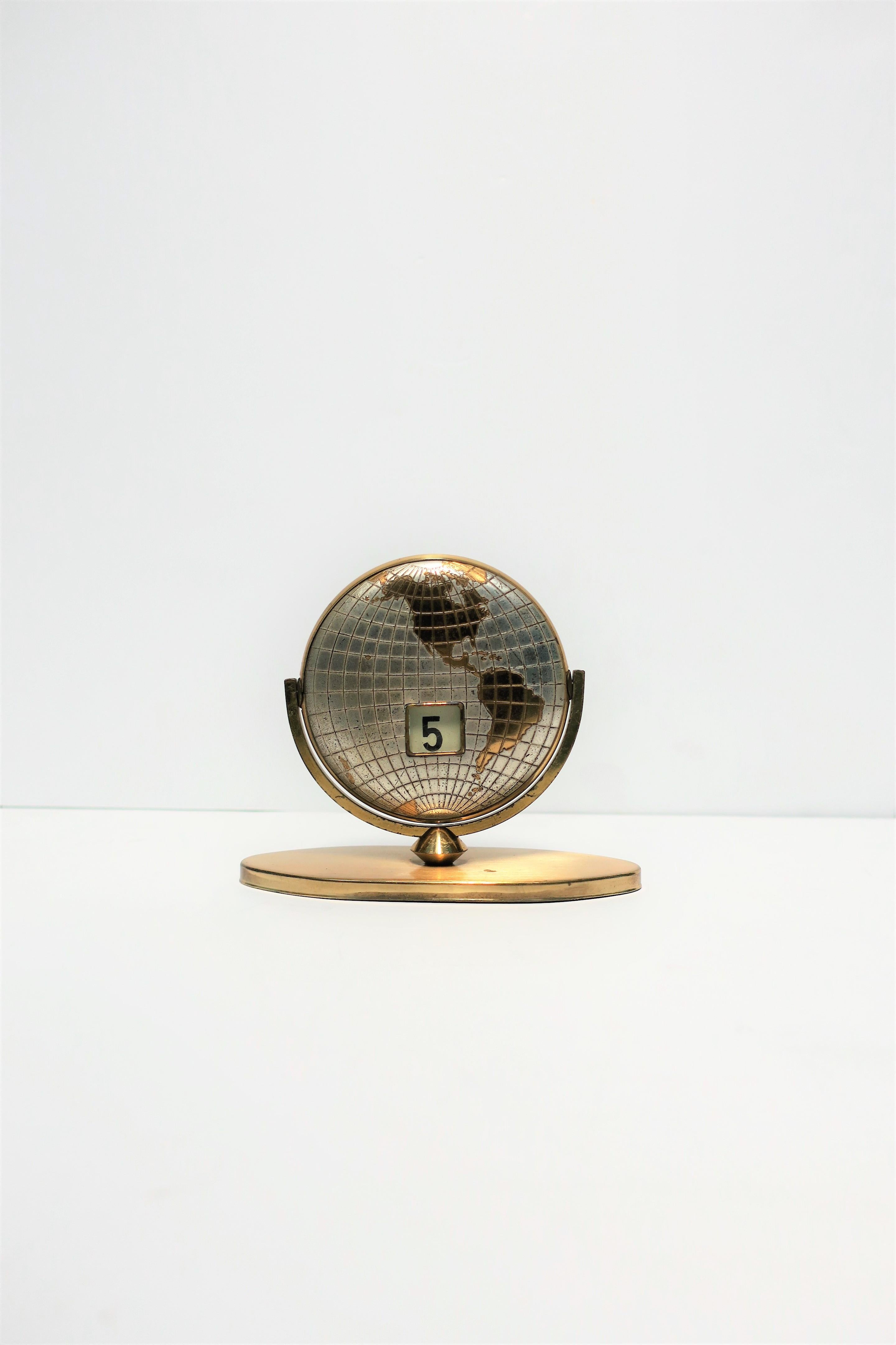 A Midcentury Modern brass and chrome world globe desk calendar, circa 1960s. Date changes by turning/flipping globe. Date on both sides. In fine working order. 

Piece measures: 5.25